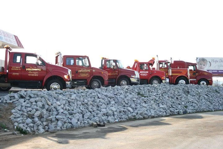 A row of six small and large tow trucks parked at Mosteller's Wrecker, Inc. main office in Downtown Chattanooga