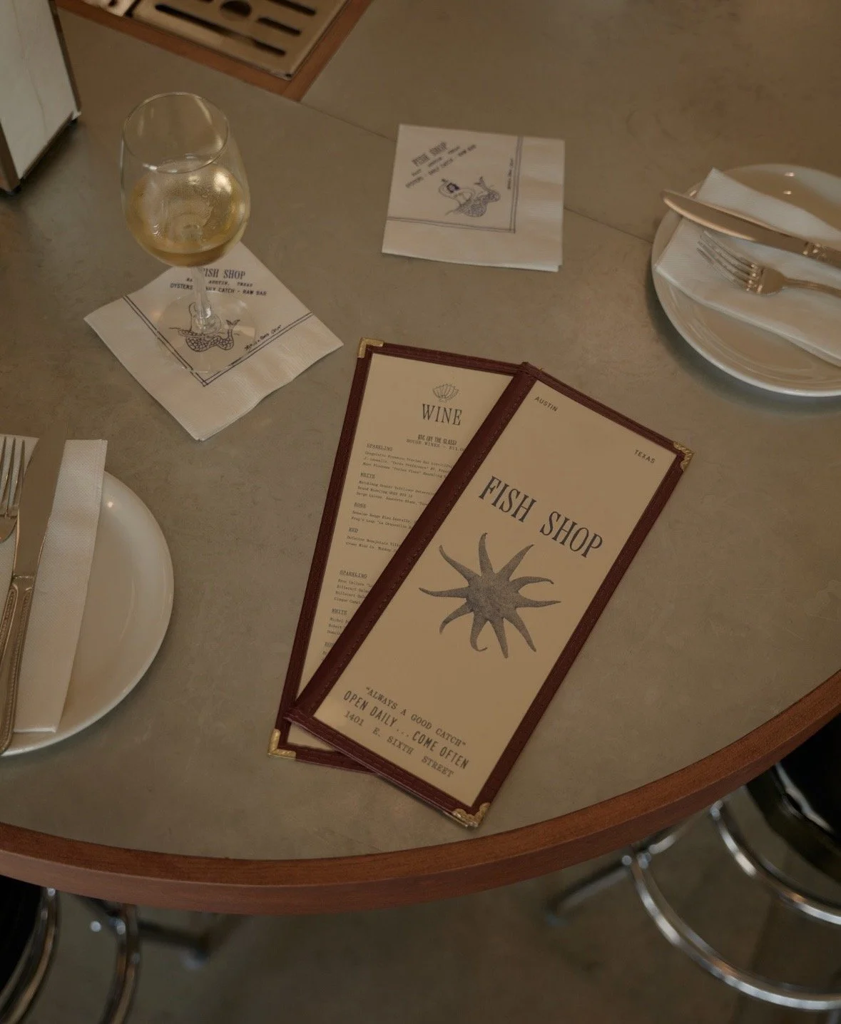 menu on the bar with a glass of wine at Fish Shop