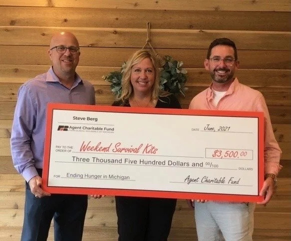 Group holding up large check donation