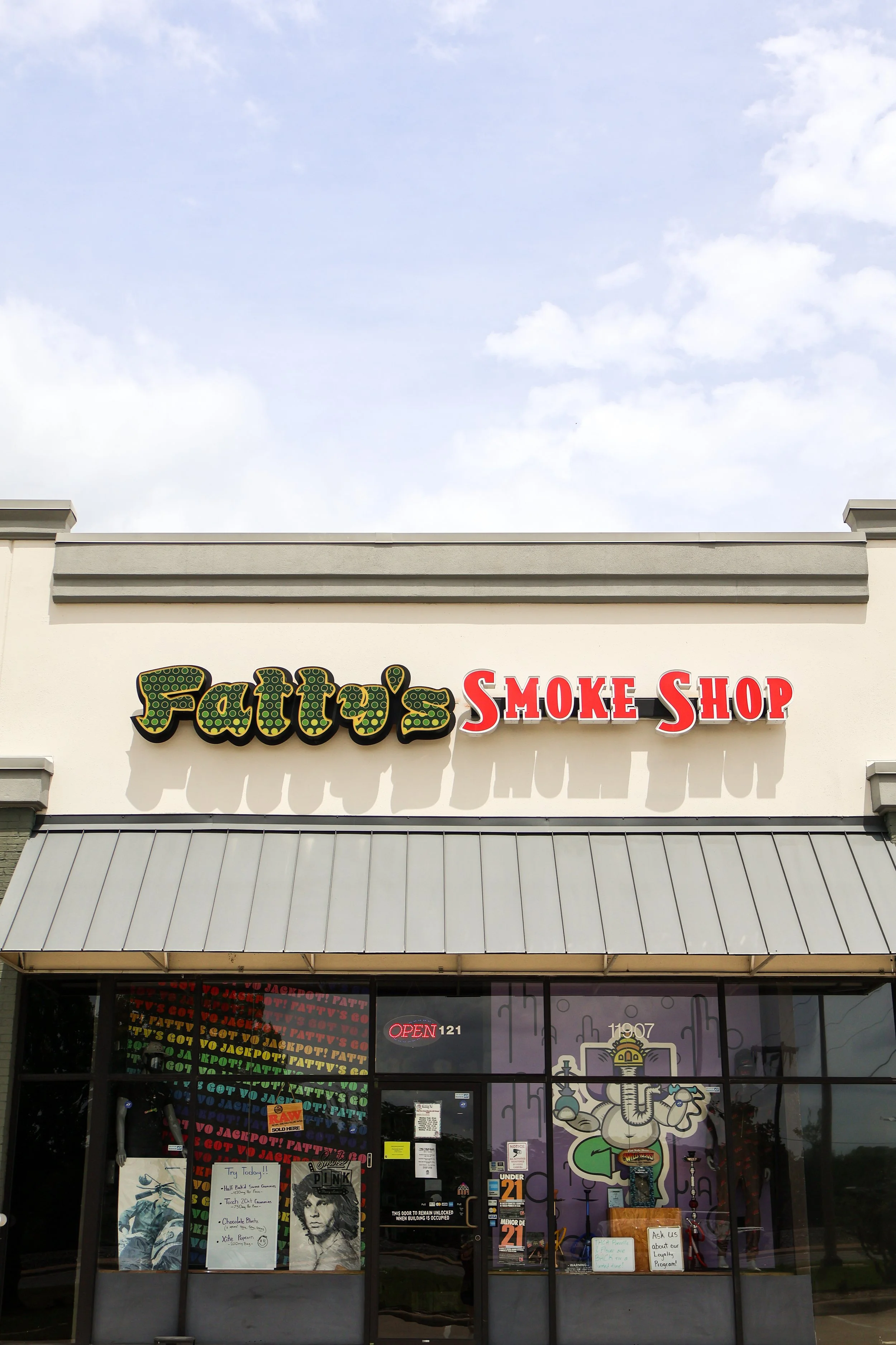 storefront of Fatty's Smoke Shop in College Station on Wellborn Road with signage and window displays, including posters and decorations inside the shop.