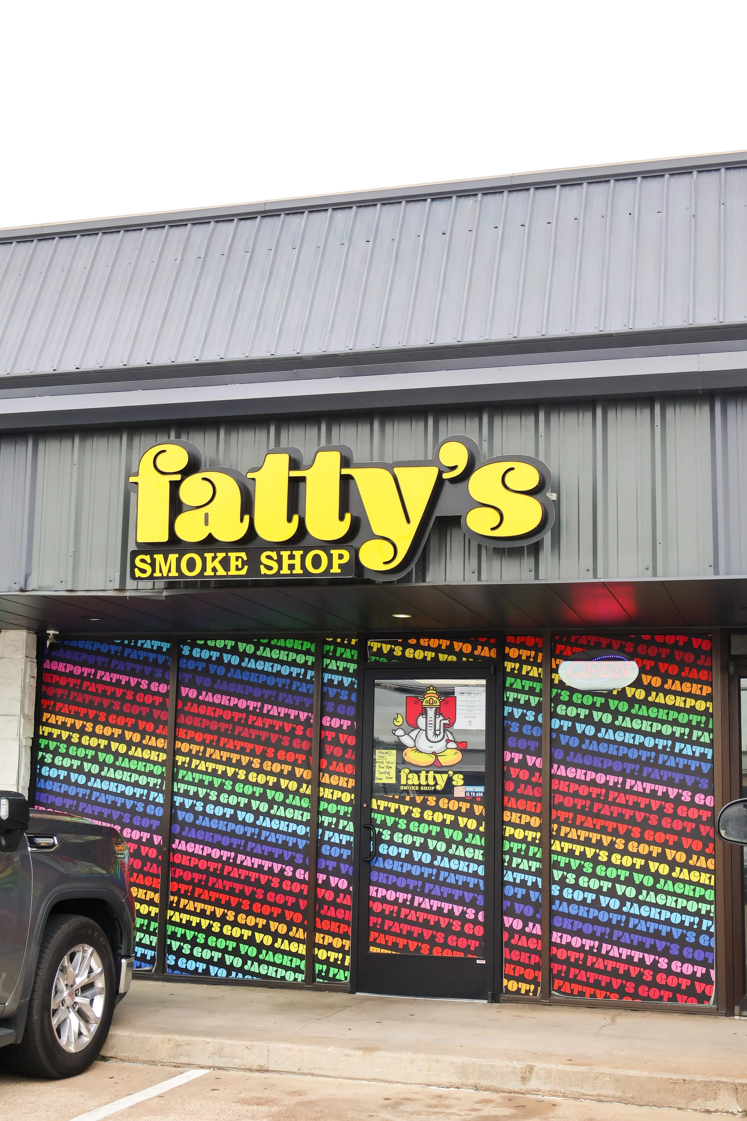 Building with yellow sign that reads "Fatty's Smoke Shop" and colorful window