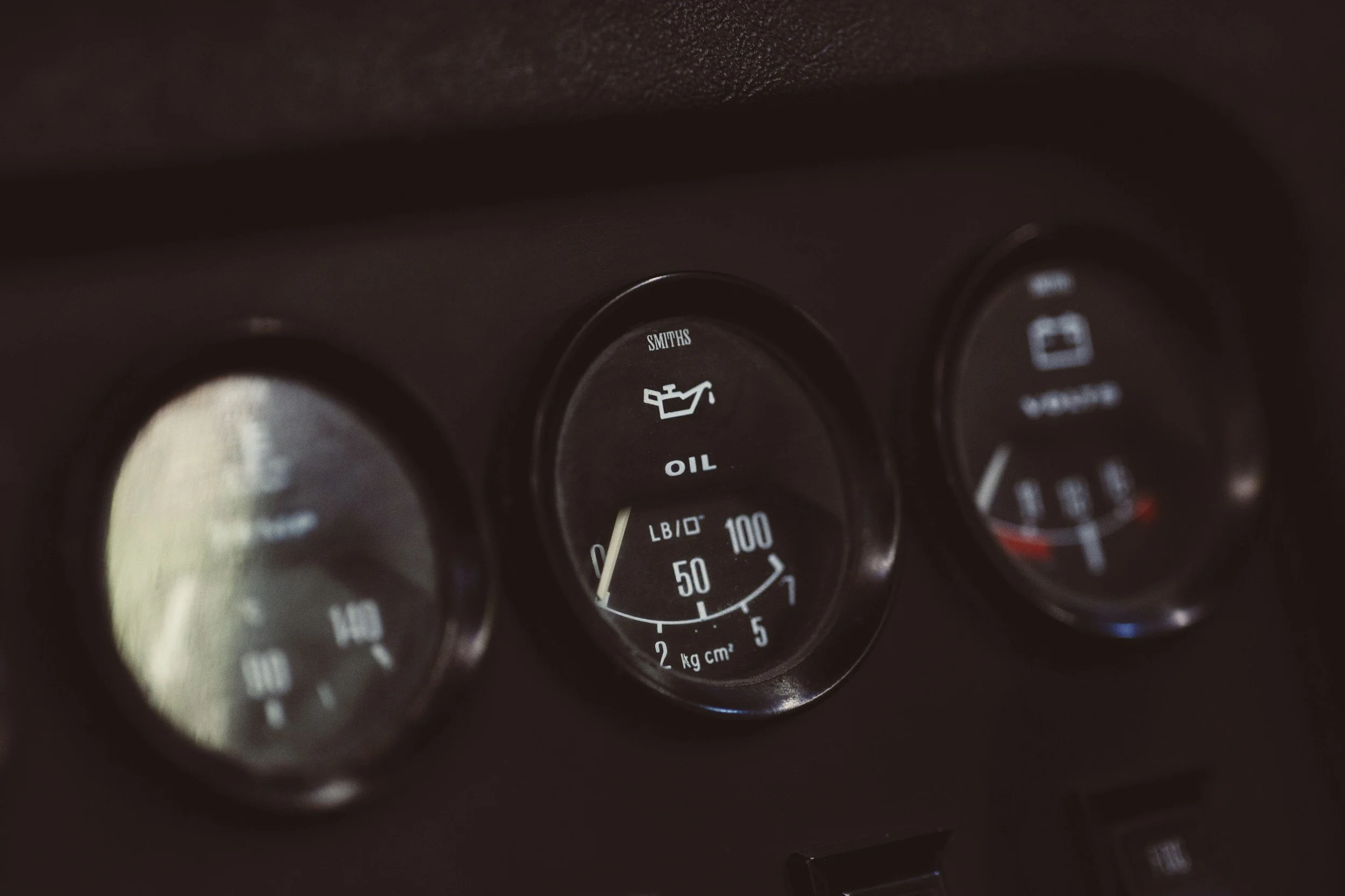 Close-up of car dashboard gauges showing oil pressure, temperature, and fuel level.