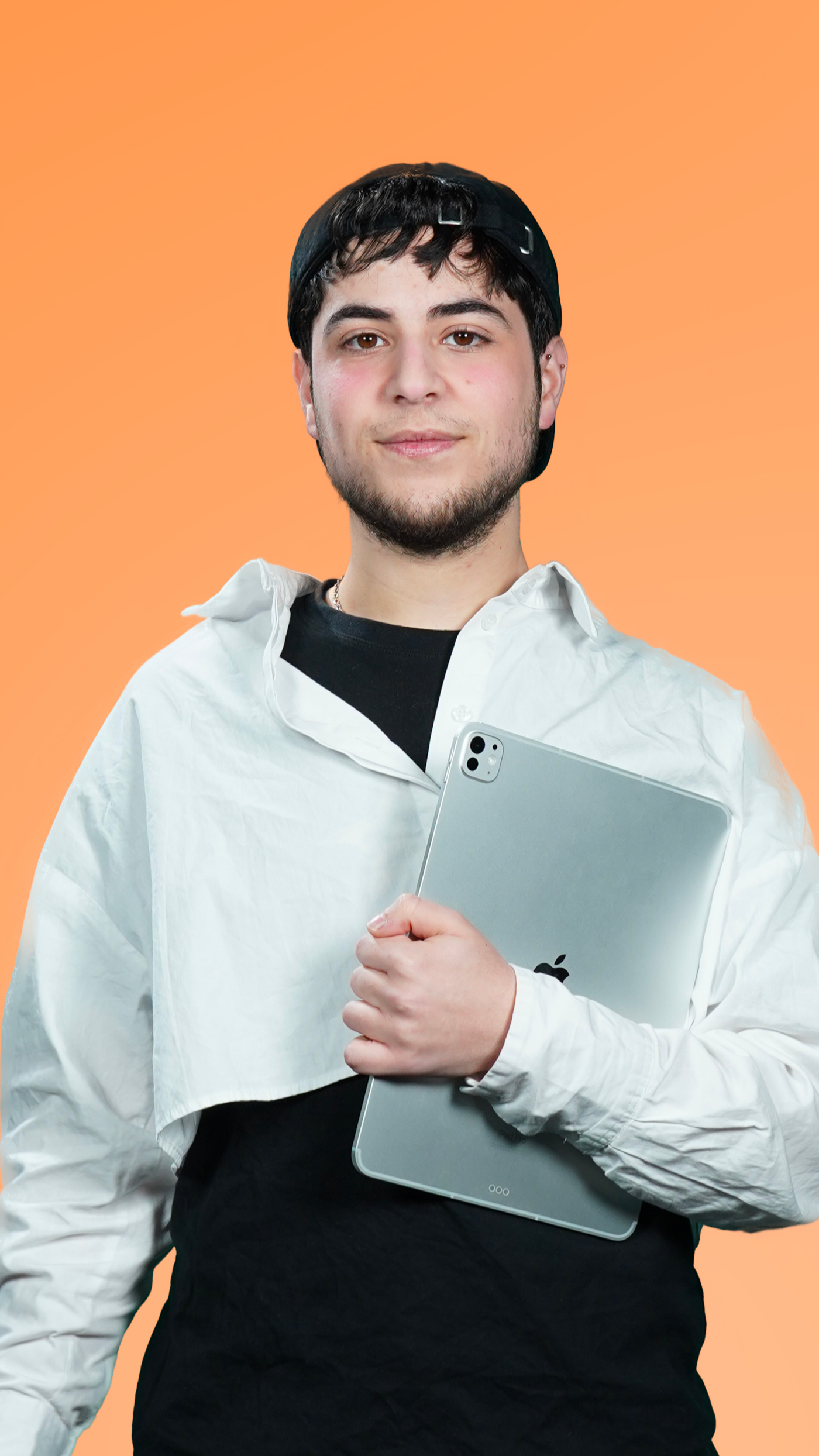 Jeune homme tenant une tablette, portant une casquette noire, une veste blanche et un T-shirt noir, avec un fond orange.