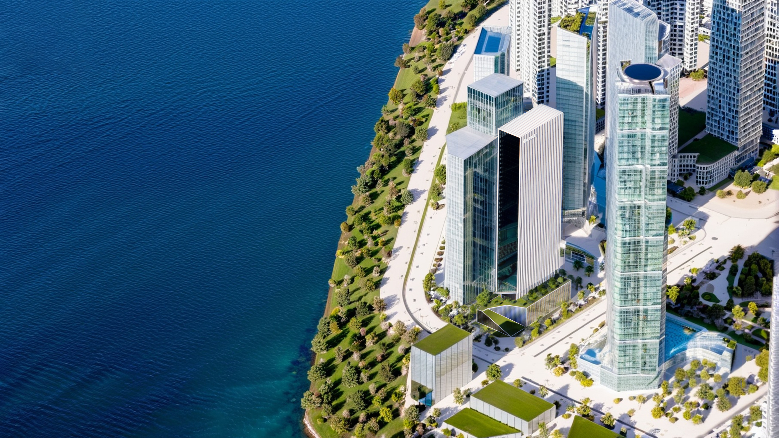 Aerial view of modern high-rise buildings along a waterfront with green parks and pathways.