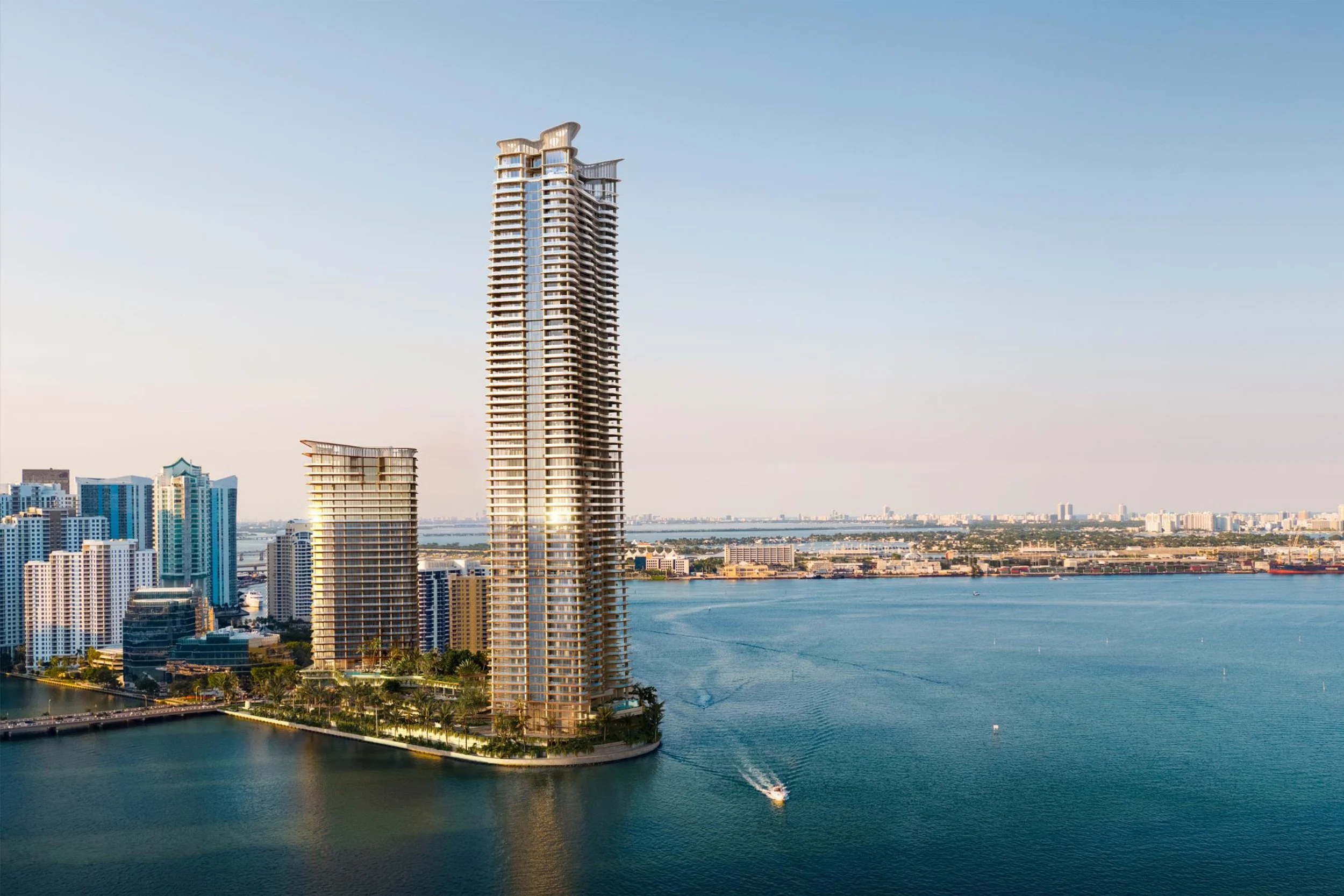 Tall modern skyscraper on a waterfront with a boat cruising nearby and cityscape in the background.