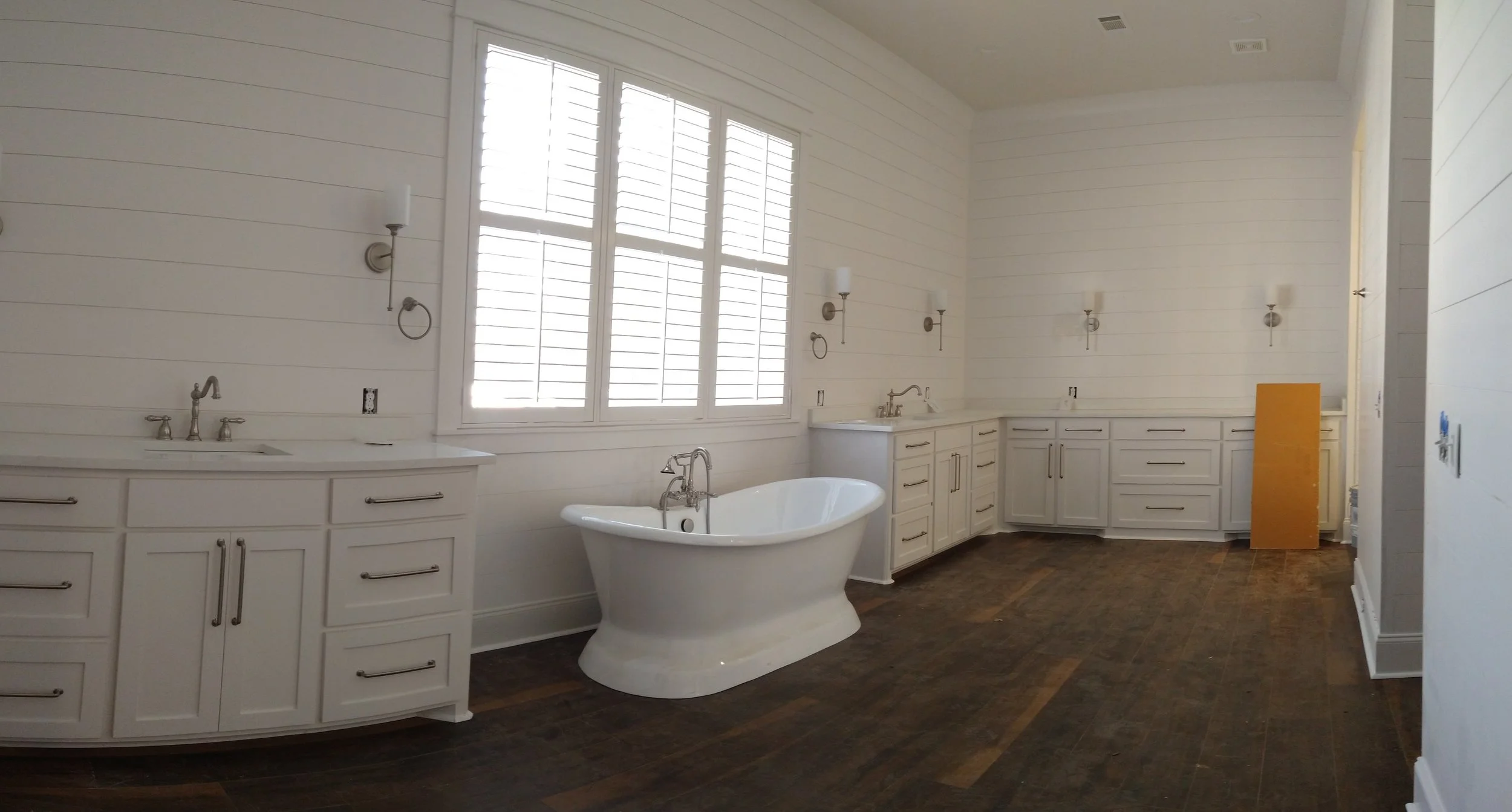 white bathroom with cabinets on shiplap walls