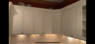 Kitchen with white cabinets, a decorative backsplash, and a matching wooden crown molding