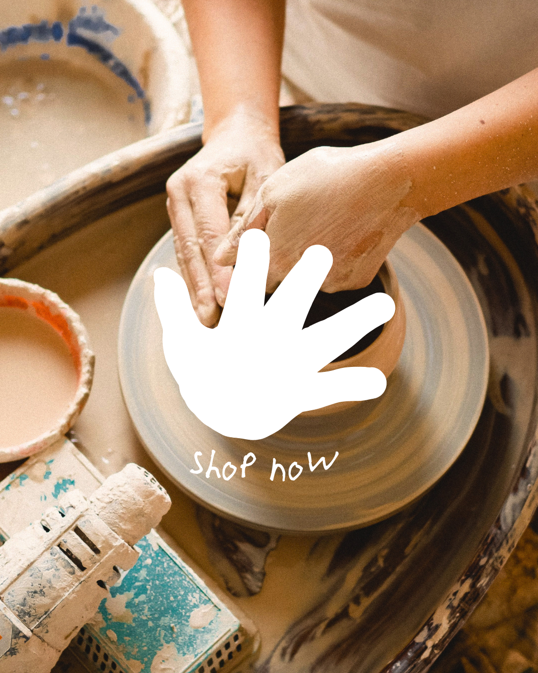 Hands shaping clay on a pottery wheel, with brushes and containers of glaze or paint nearby, and an overlay text saying 'Shop Now' with a hand-drawn icon of a hand.