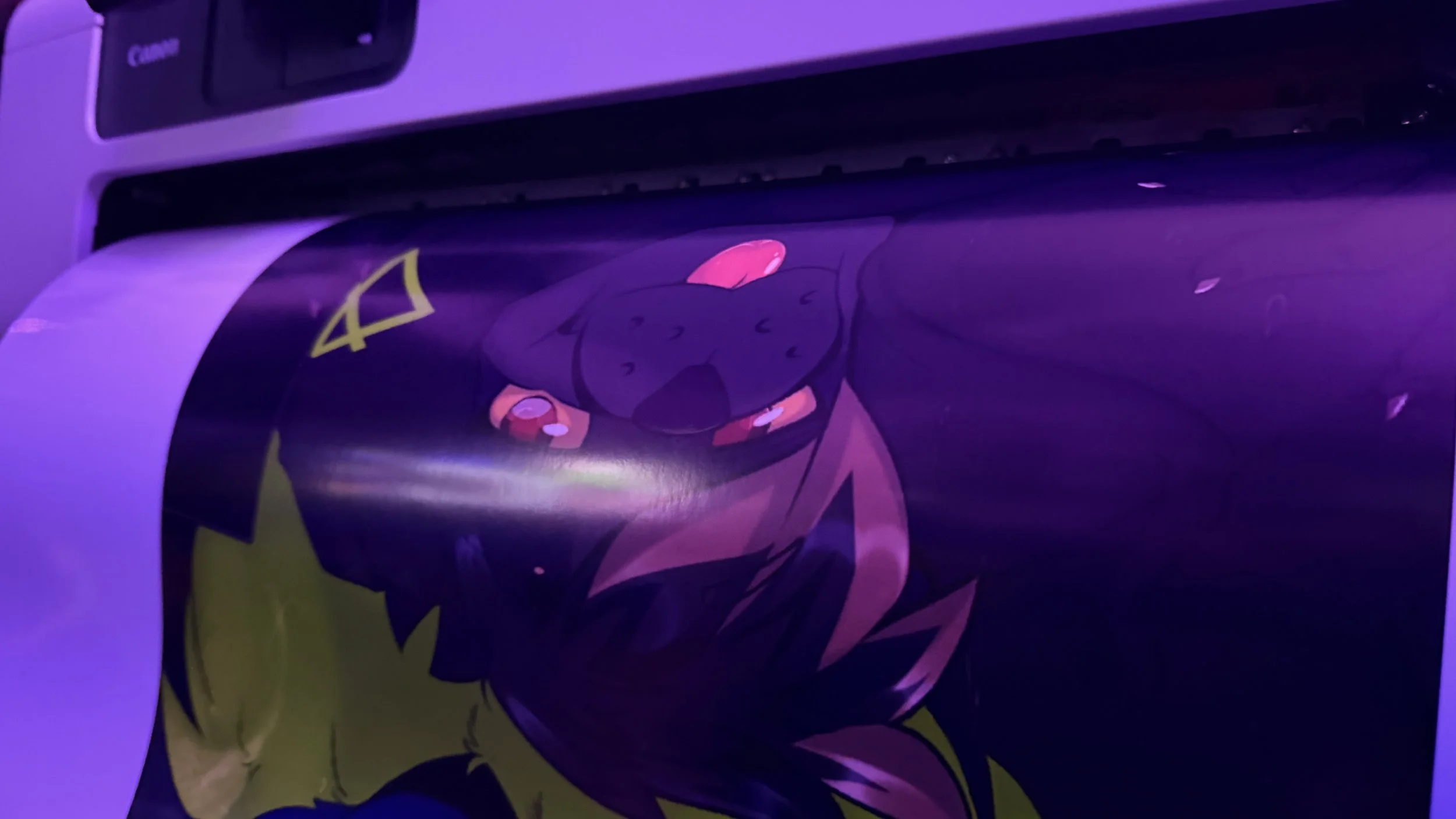 A printed poster featuring a stylized anime or cartoon character with purple hair, pink eyes, and a yellow and black outfit, illuminated by purple lighting.