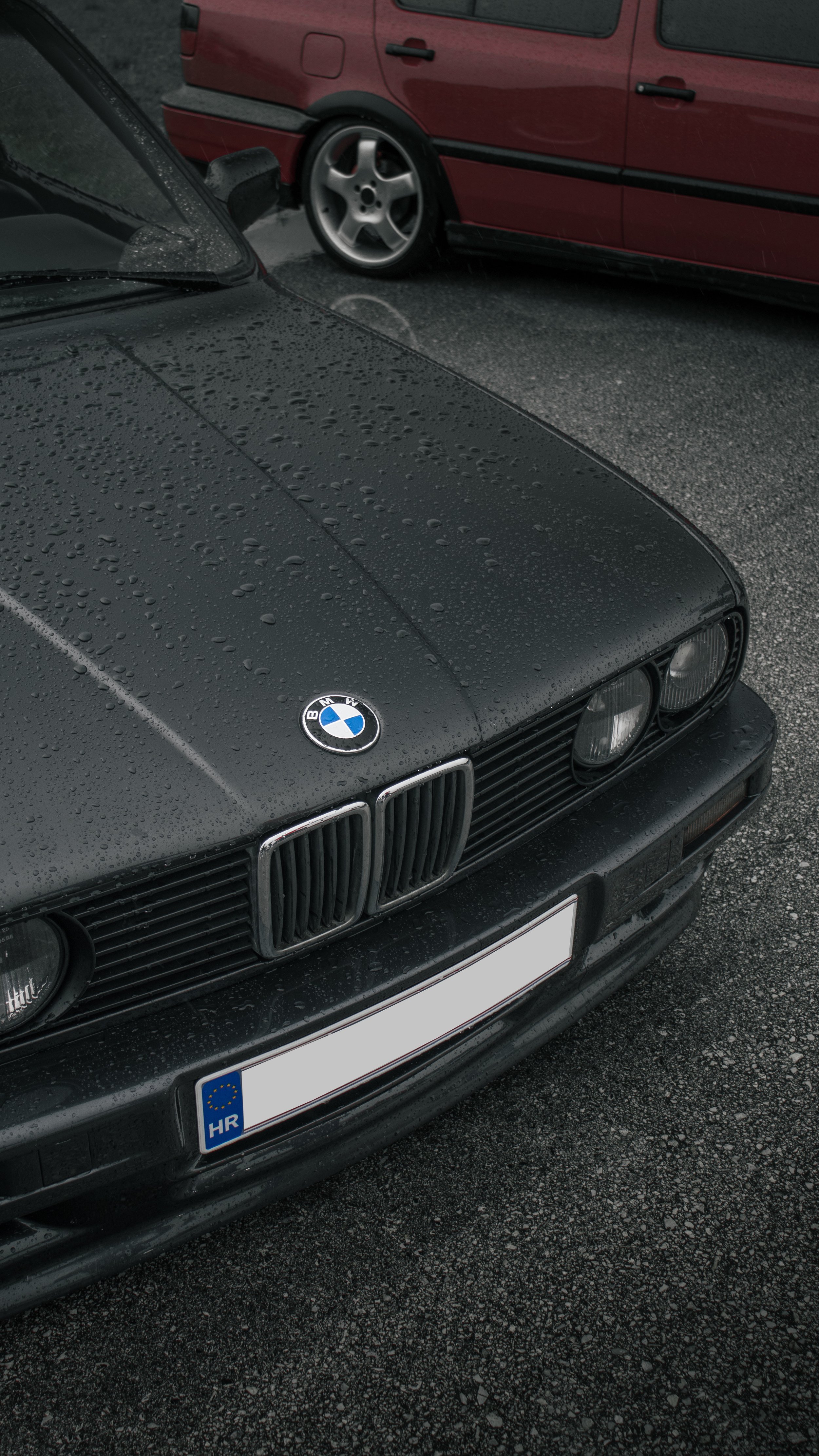 Detalj prednjeg dijela tamnosivog BMW-a E30, farovi i maska hladnjaka