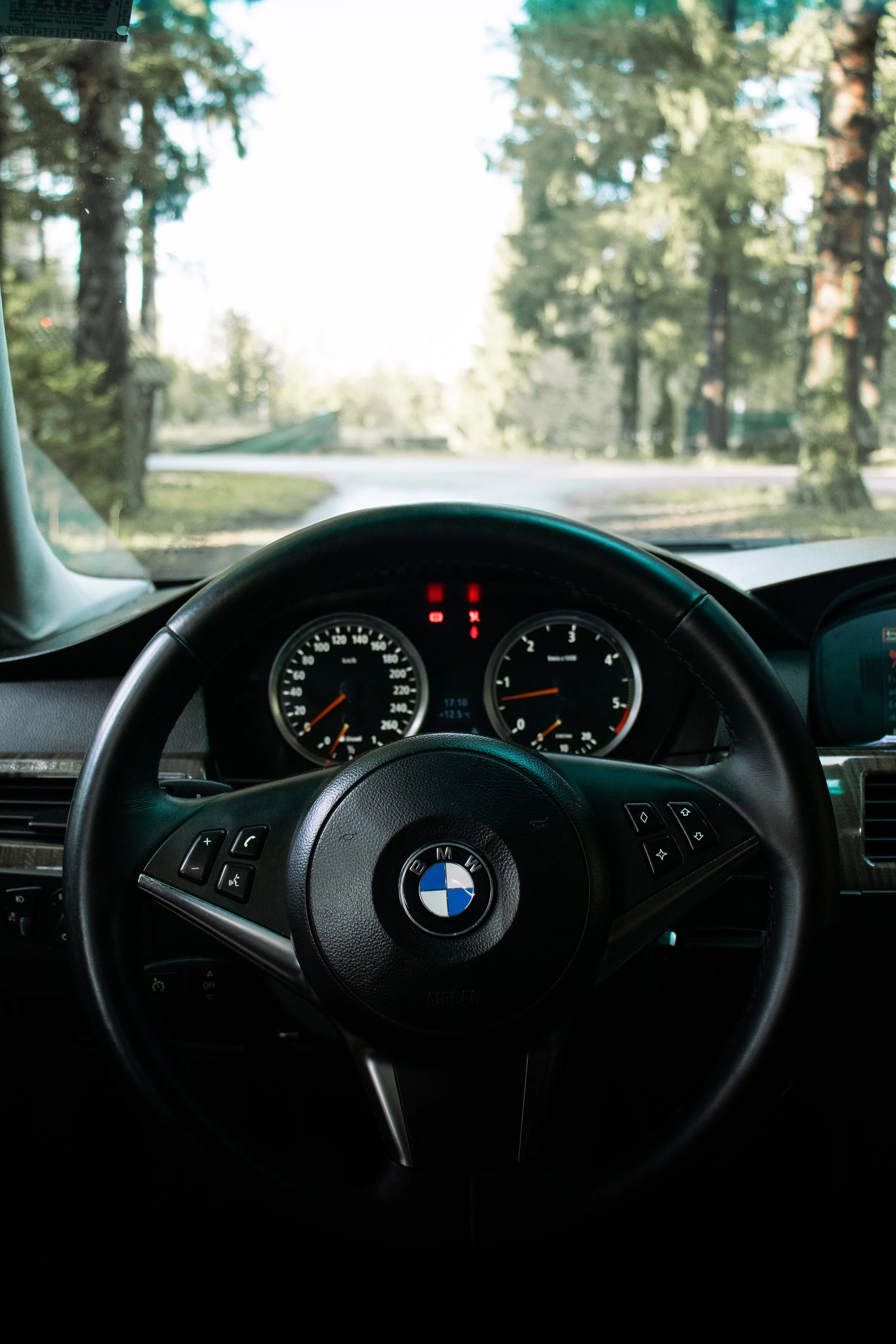 Profesionalna fotografija Point-of-View kuta koja prikazuje upravljač, kontrolnu ploču i brzinomjer BMW e60, snimljena s vozačevog sjedala.