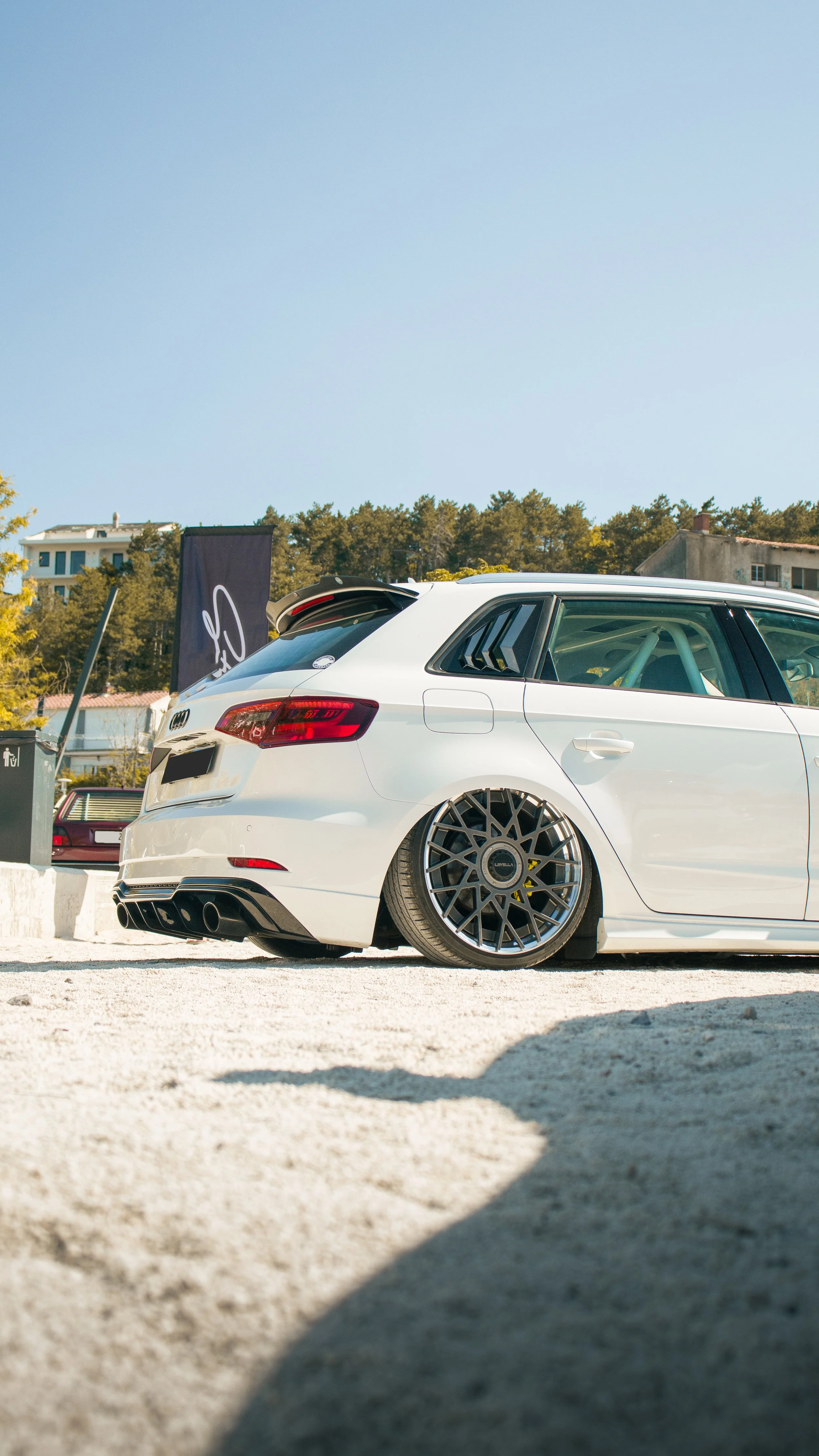 Bijeli spušteni Audi A3 s prilagođenim Rotiform naplatcima i Roll barom, fotografiran iz niskog kuta na car meetu u Hrvatskoj.