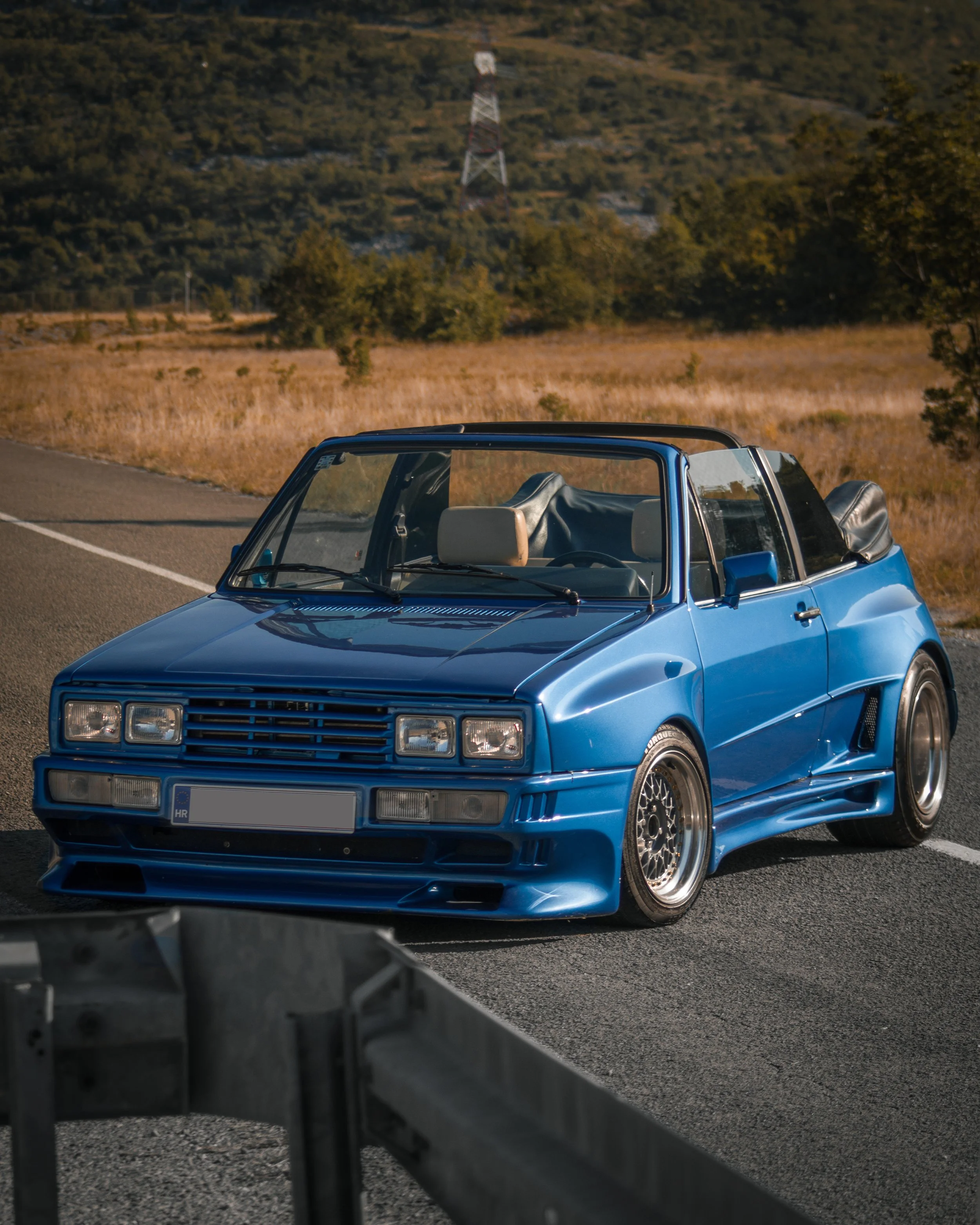 Moderniran plavi Volkswagen Golf MK1 sa Rieger GTO Widebody Kit i sniženim ovjesom, pogled sprijeda na susretu automobila