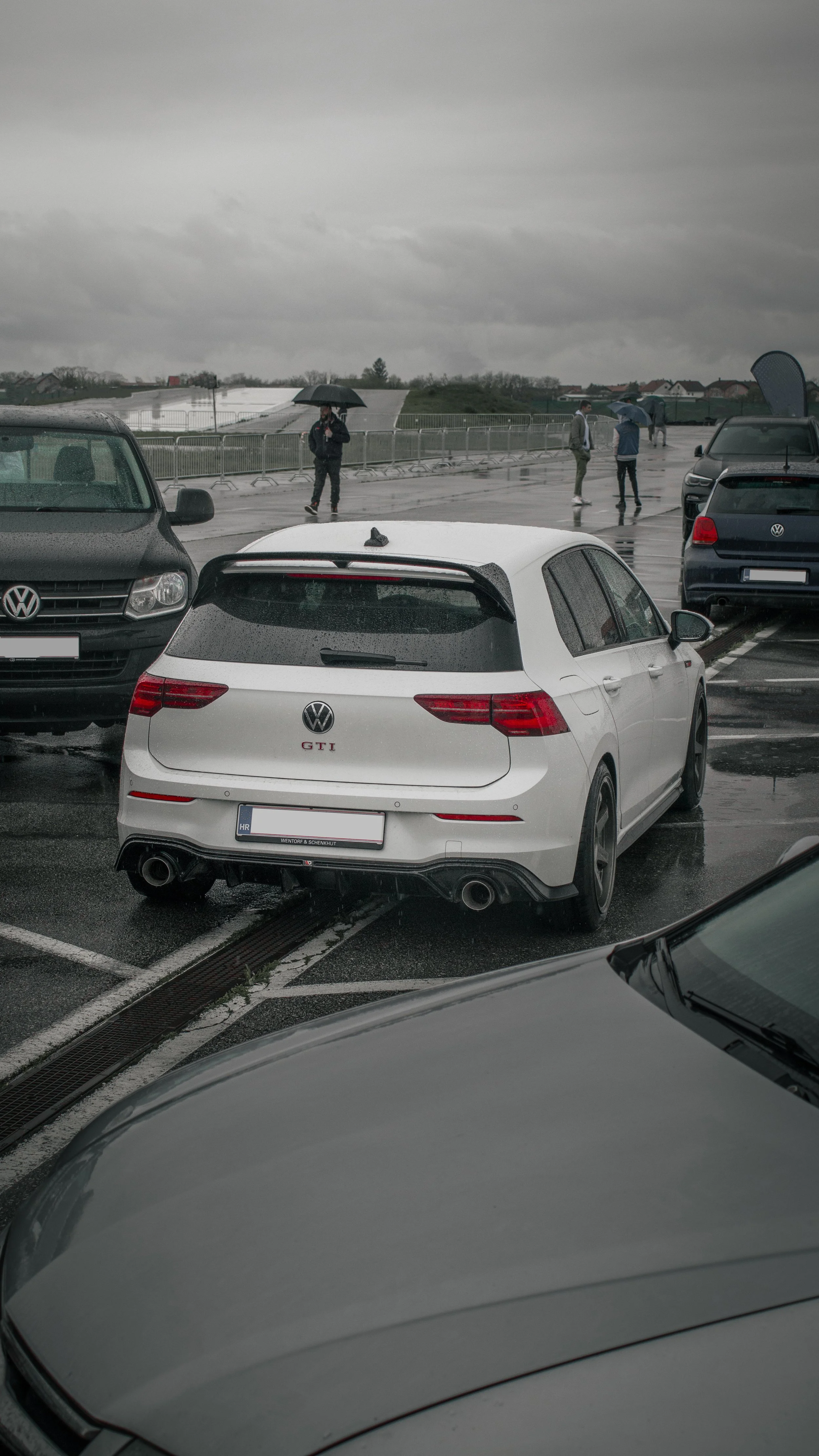 Golf 8 GTI parkiran na kišnom susretu automobila, oblačno nebo