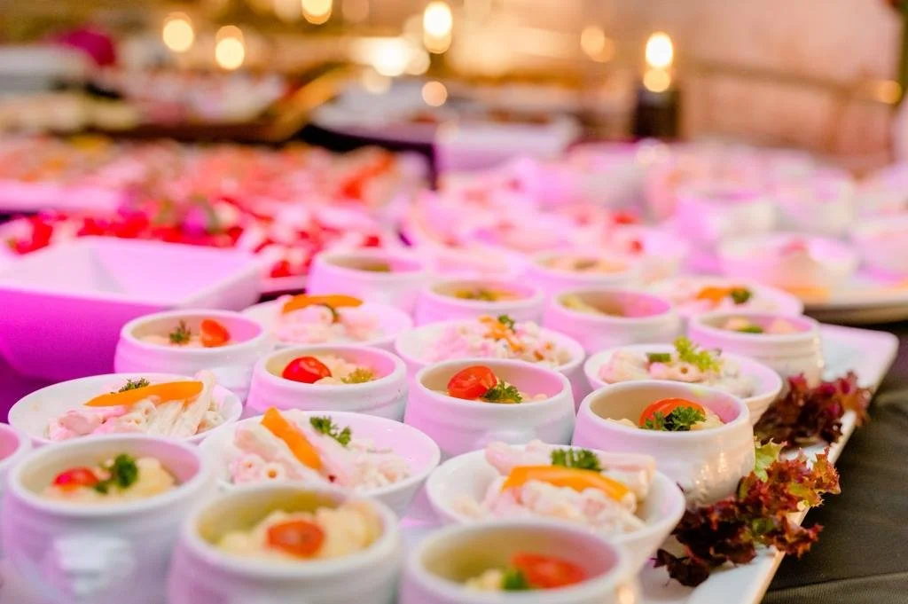 Verschiedene kleine Portionen mit Vorspeisen oder Salaten, dekorativ auf einem Buffet-Teller angerichtet.