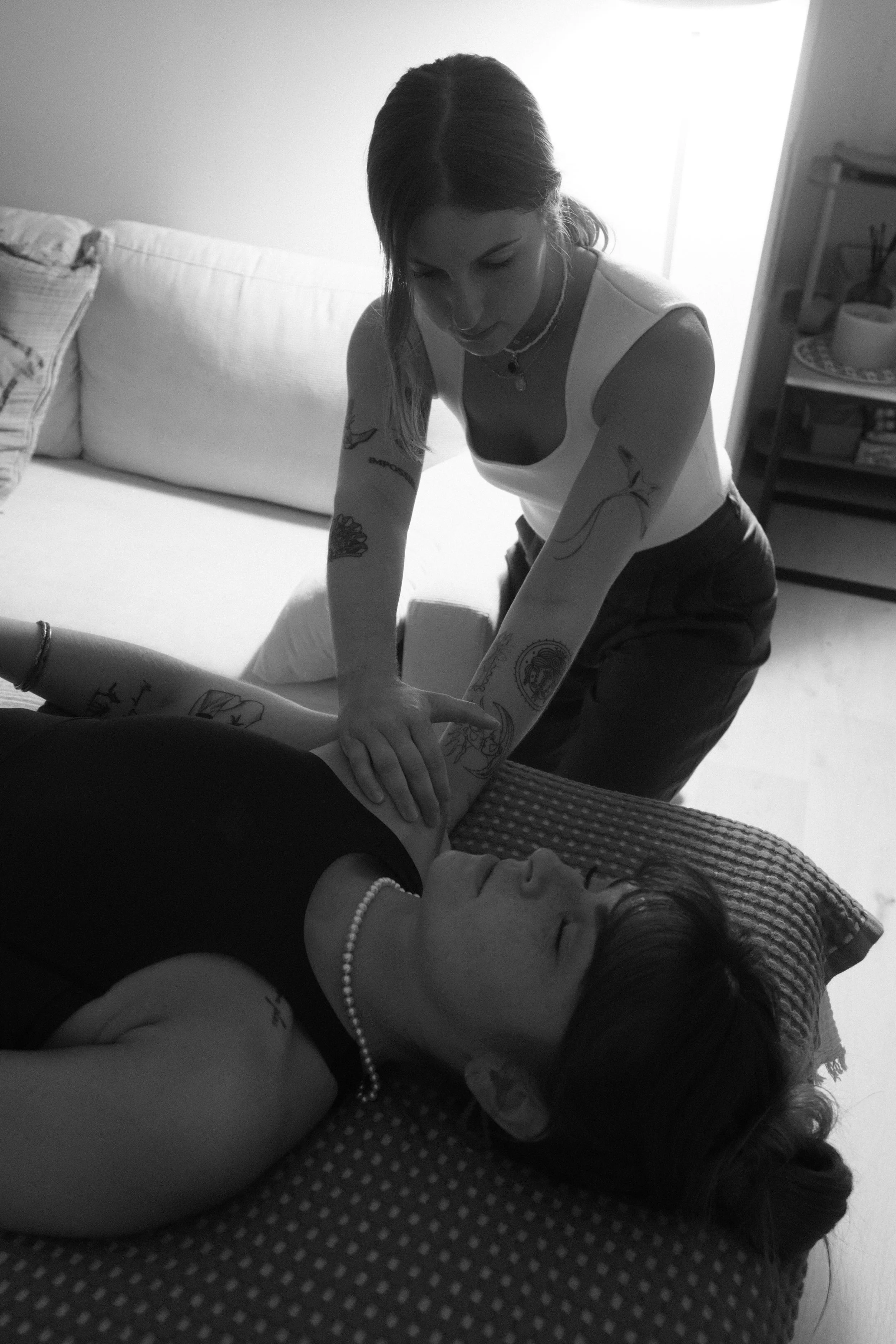 Une femme effectuant une mobilisation douce de l'articulation d'une épaule dans le cadre d'une séance de rebouteux. L'ambiance est calme et détendue.
