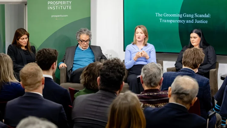 Panel discussion at Prosperity Institute about grooming gang scandal, seating of three women speakers on stage with audience facing them.