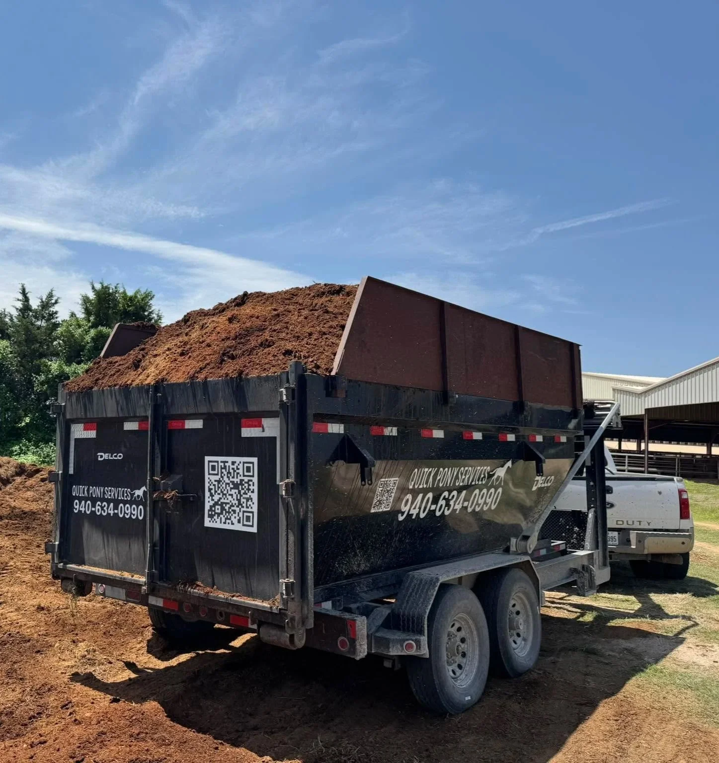 A large dump trailer removing horse manure from a horse ranch in Whitesboro Texas.