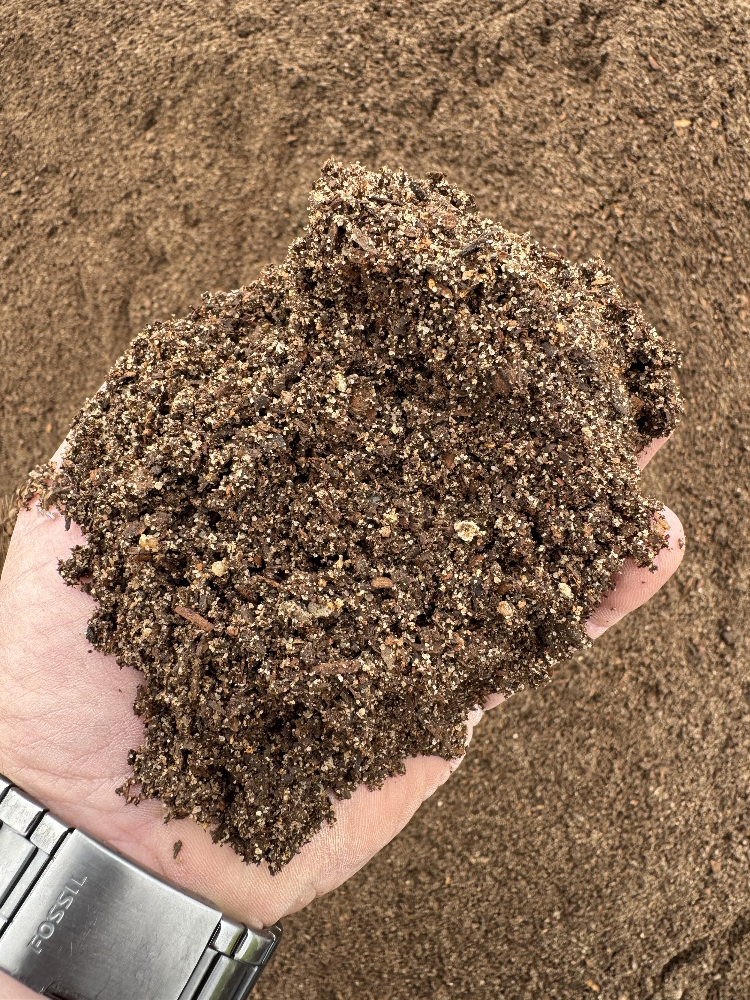 A hand full of raised bed compost mix from Quick Pony Farms in Gainesville Texas.