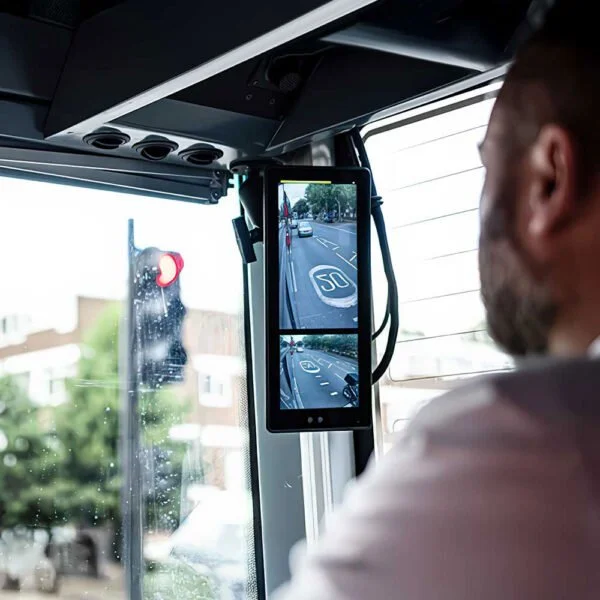 Bus operator using a Stoneridge MirrorEye interior camera monitor to view the vehicle side and surrounding roadway.