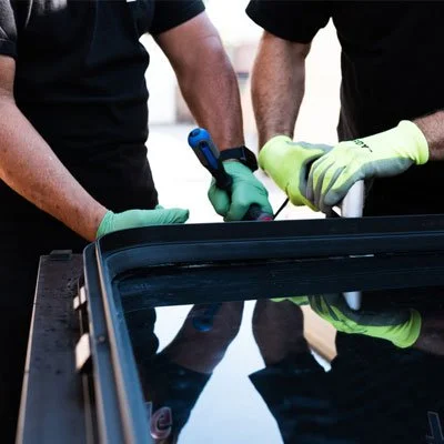TransitGuard technician rebuilding a damaged hidden-frame transit bus window assembly.