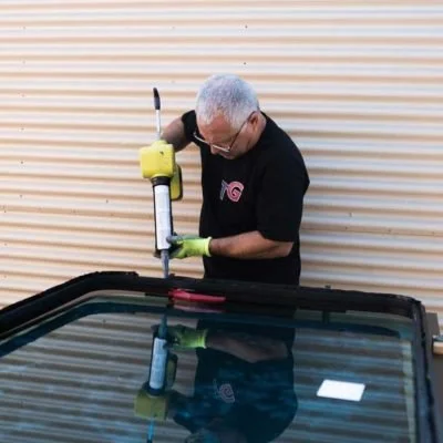 TransitGuard technician rebuilding a damaged hidden-frame transit bus window assembly.