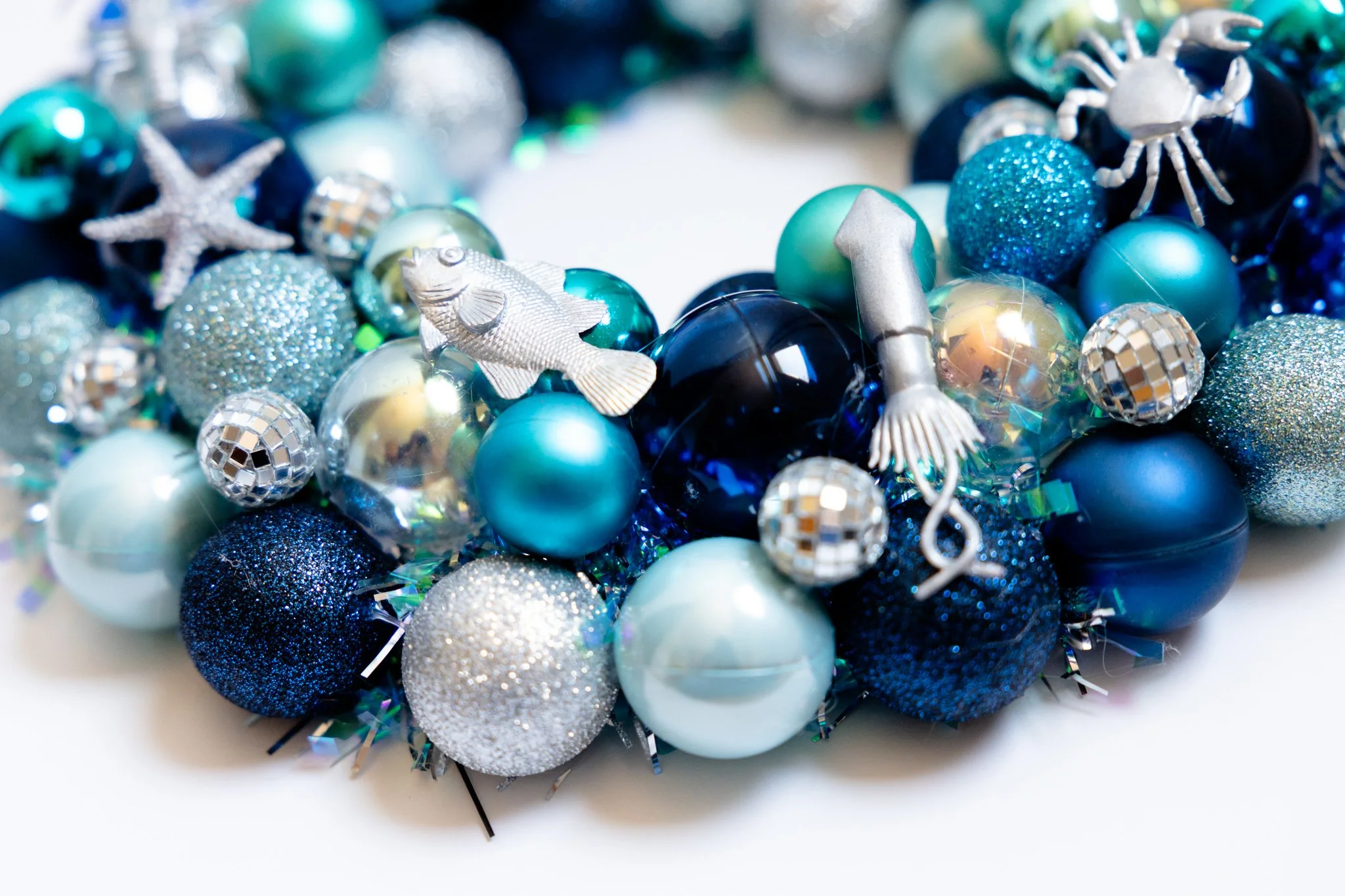 Silver fish and squid on handmade blue ornament wreath with disco balls