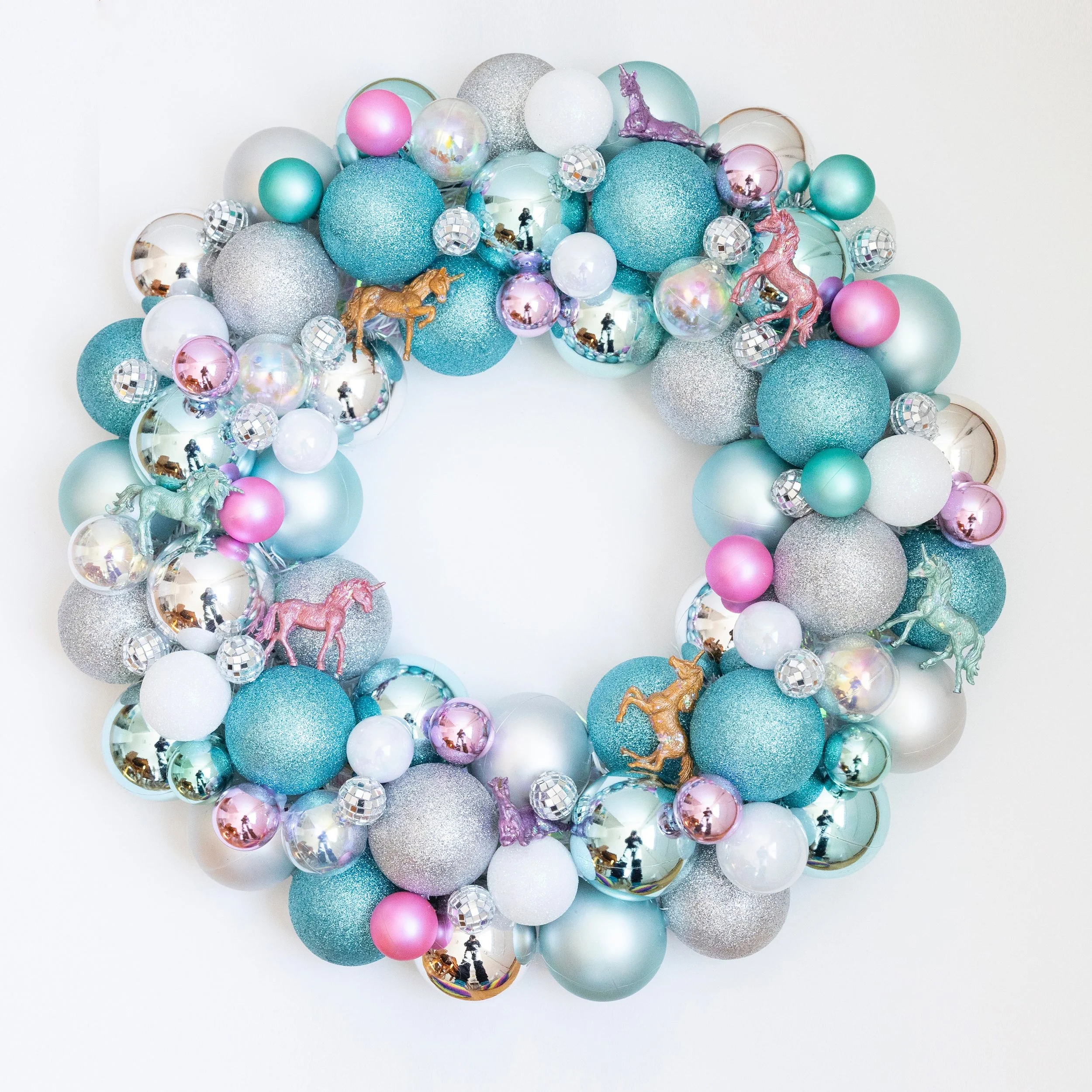 I made this unicorn wreath during the big snow storm this winter. I hand painted the unicorns and then put glitter on them, and think it has kind of a wintery vibe with the colors I chose. I love it, but it's big to store, so it's for sale on my webs