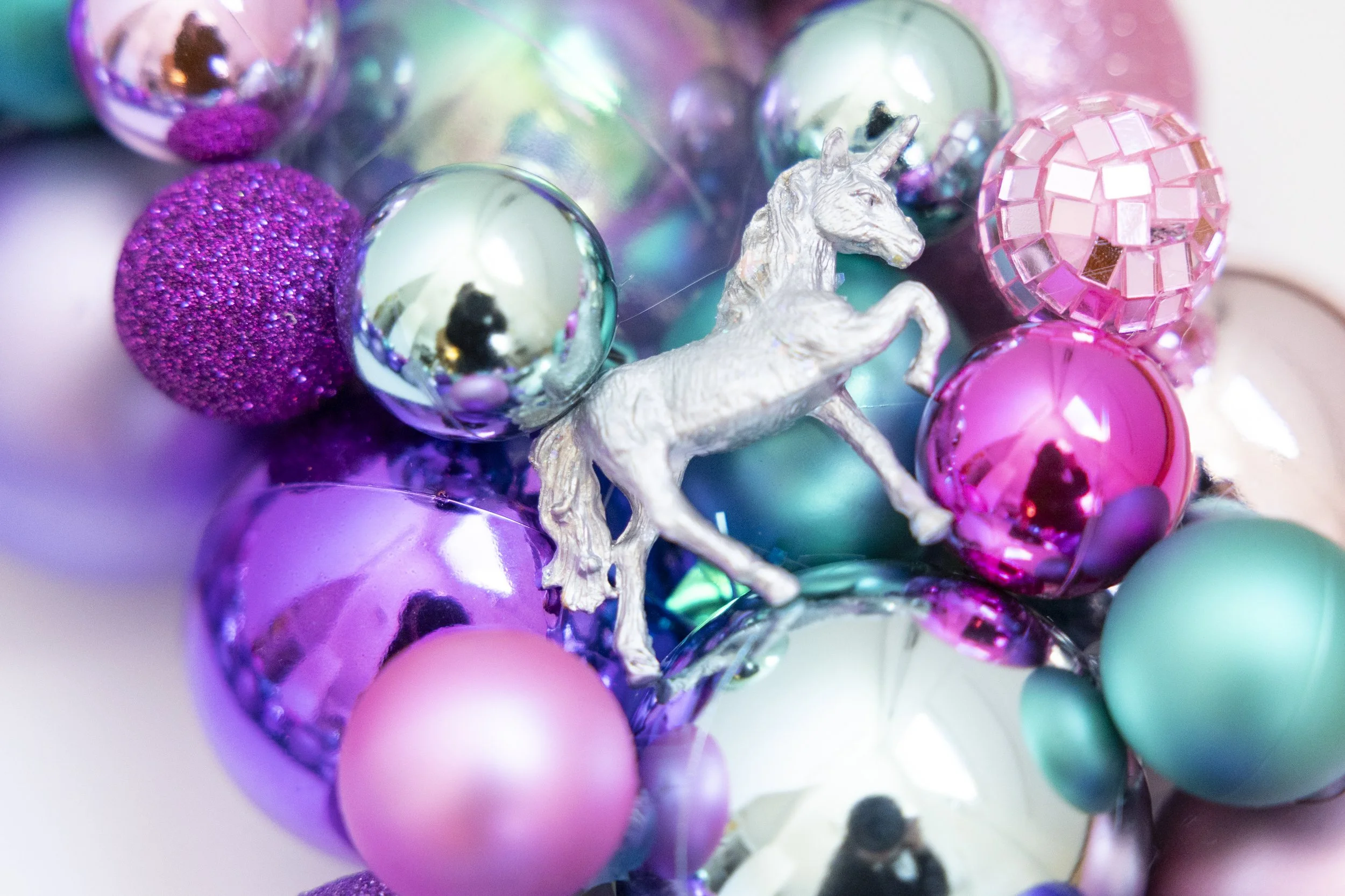 Silver shiny unicorn wreath with pink, turquoise and purple ornaments