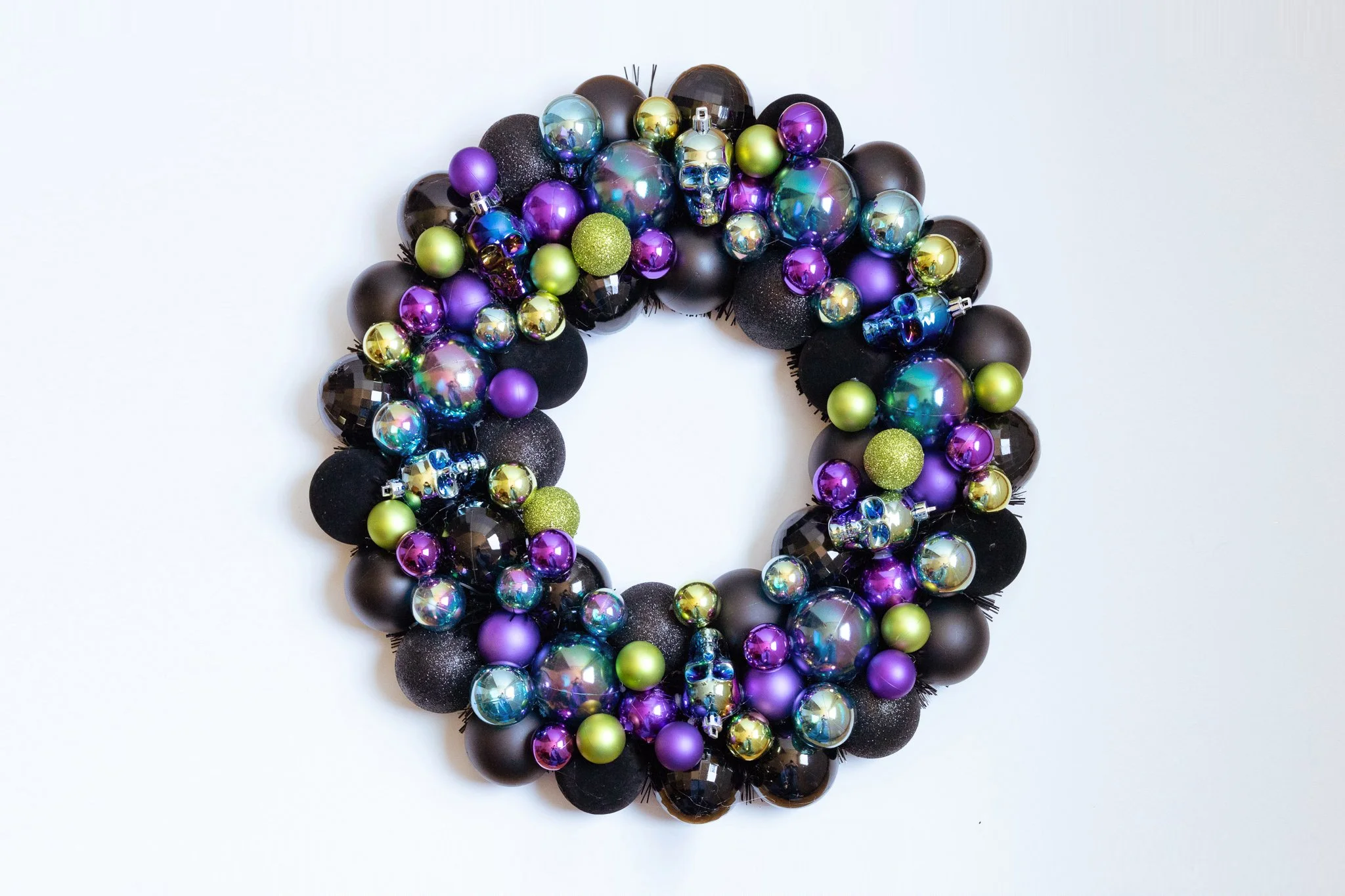 Ornament wreath with black, purple, green and iridescent ornaments and iridescent skulls