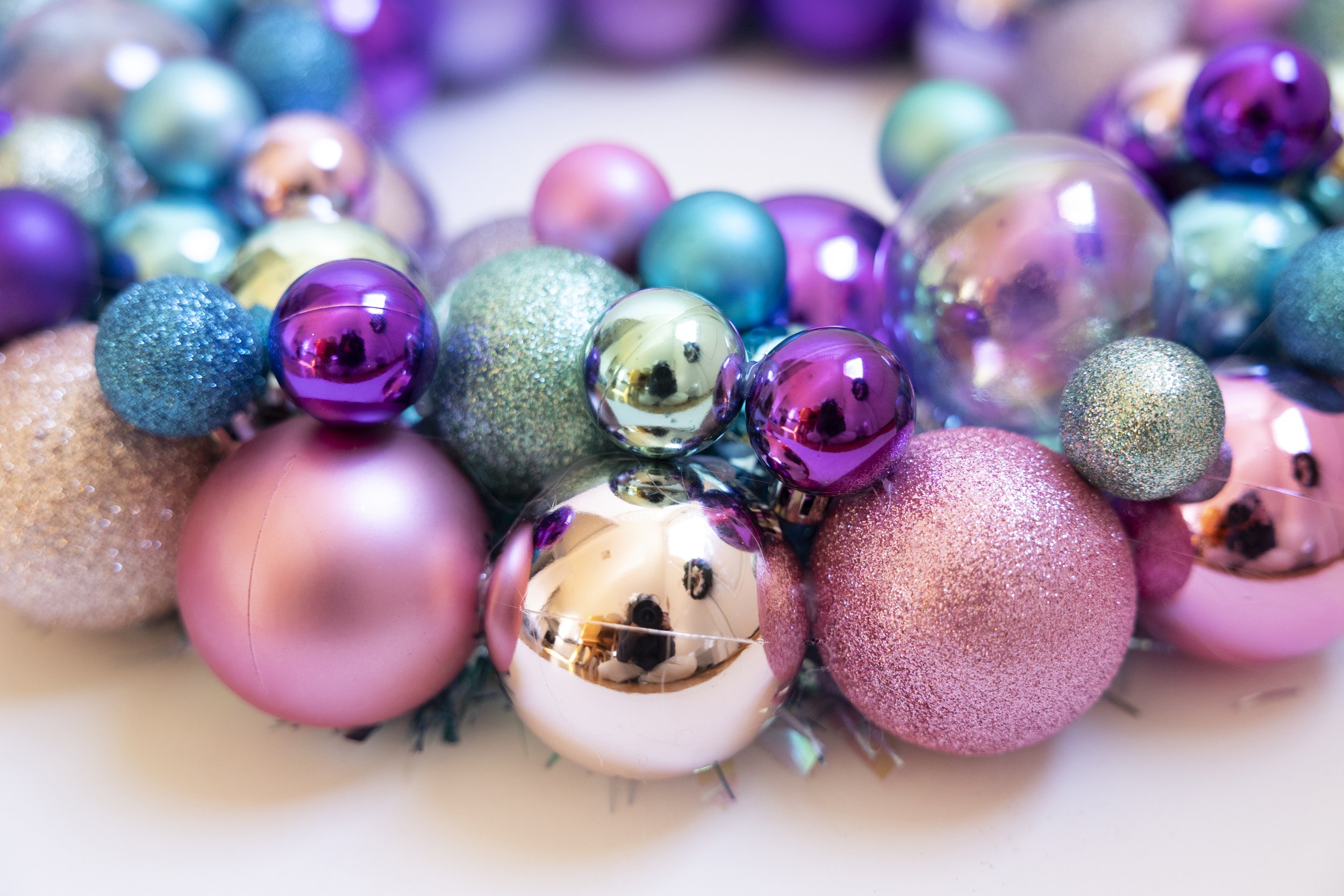 Handmade wreath with pink, blue and purple ornaments