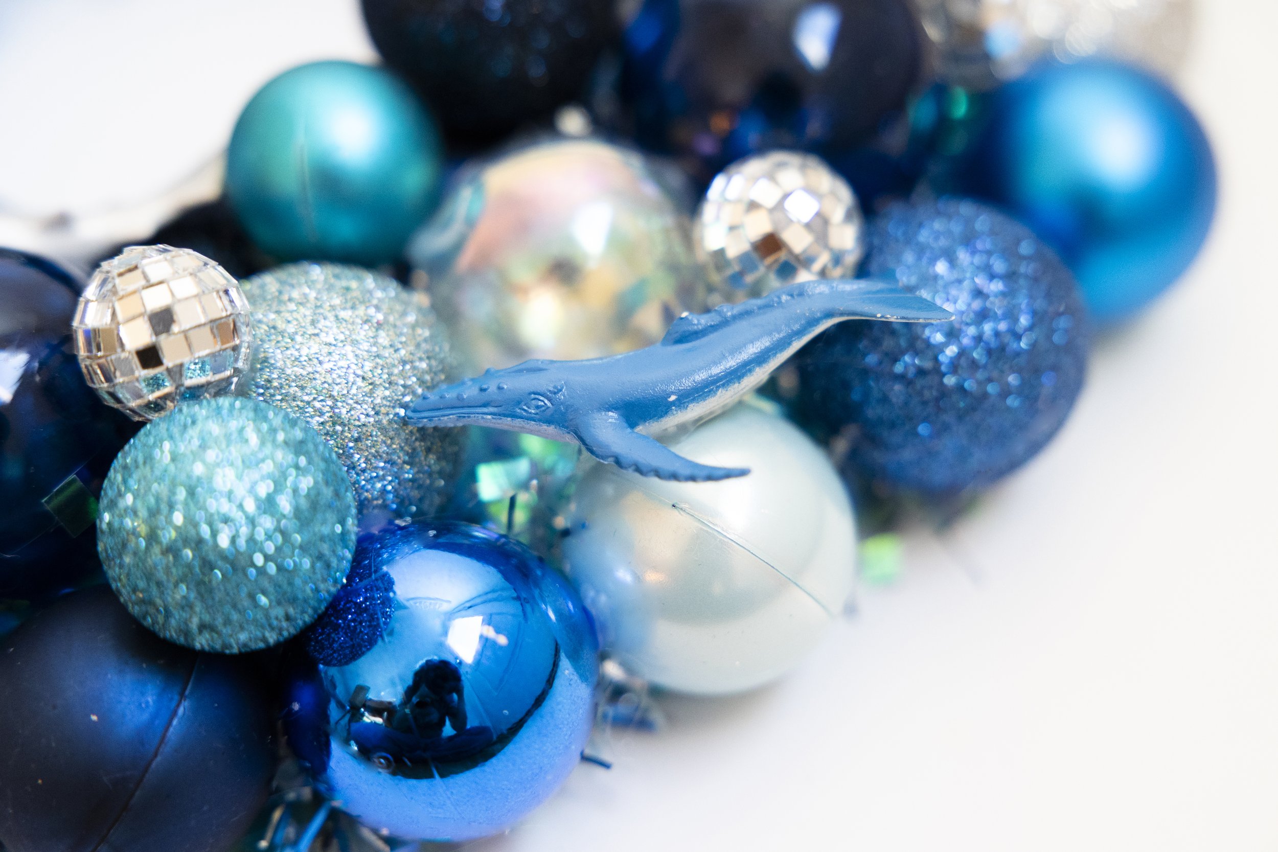 Blue whale on handmade wreath made with blue ornaments and disco balls