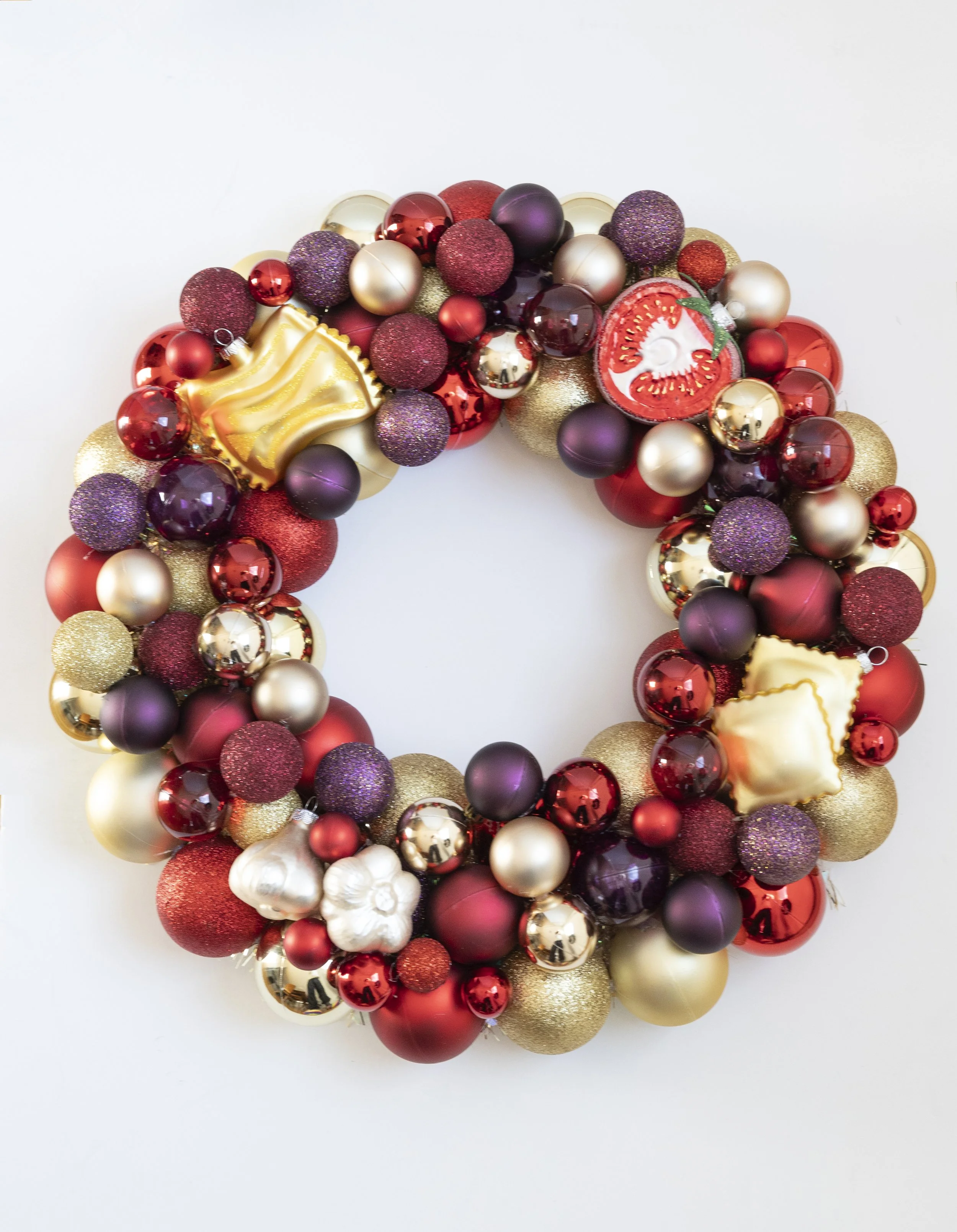 Colorful handmade wreath with pasta, garlic, and tomato ornaments