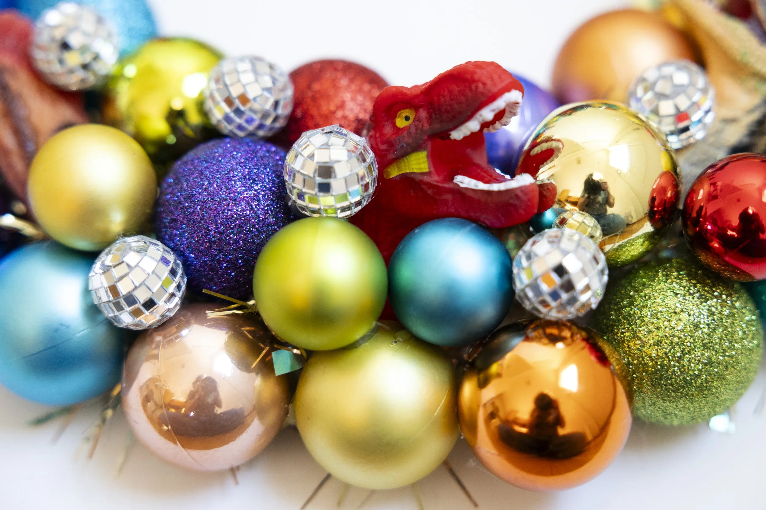 Handmade wreath with colorful ornaments, disco balls and dinosaurs