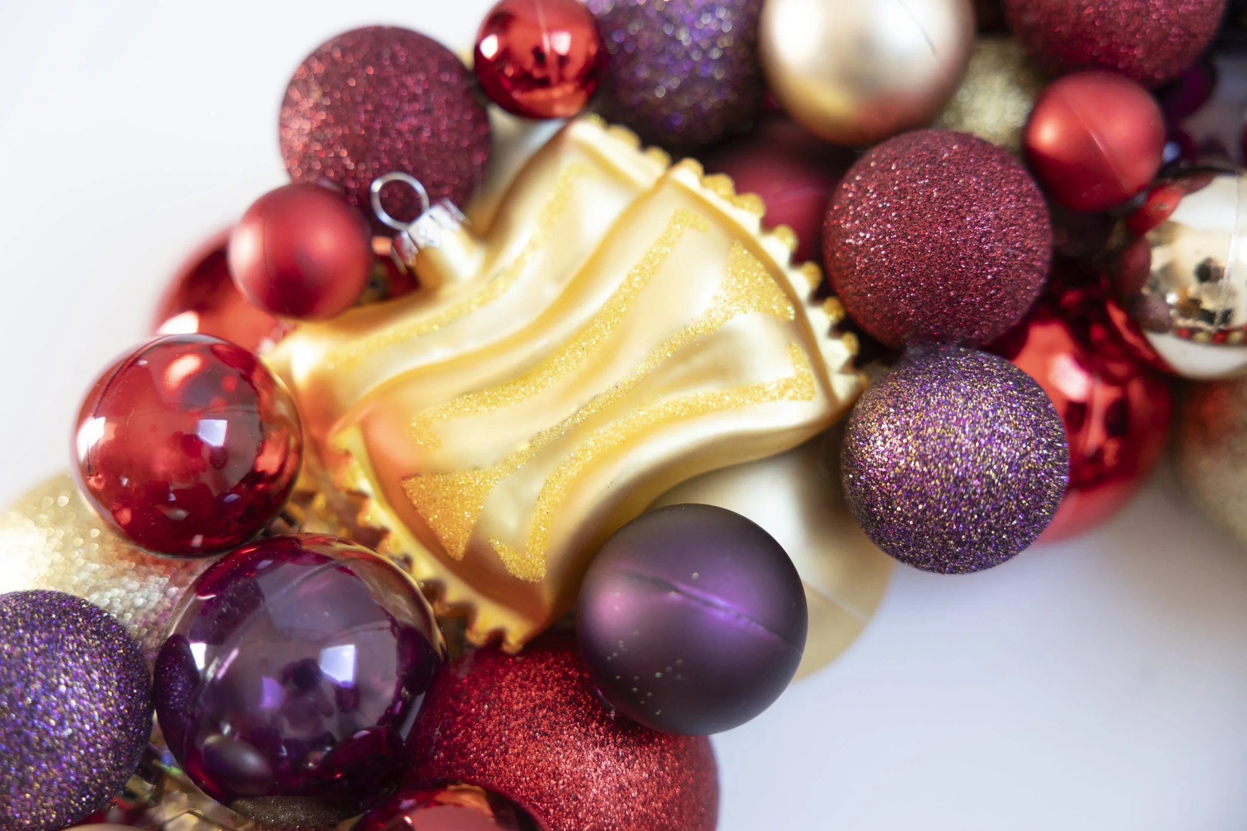 Farfalle bow tie ornament on red, gold and purple handmade wreath