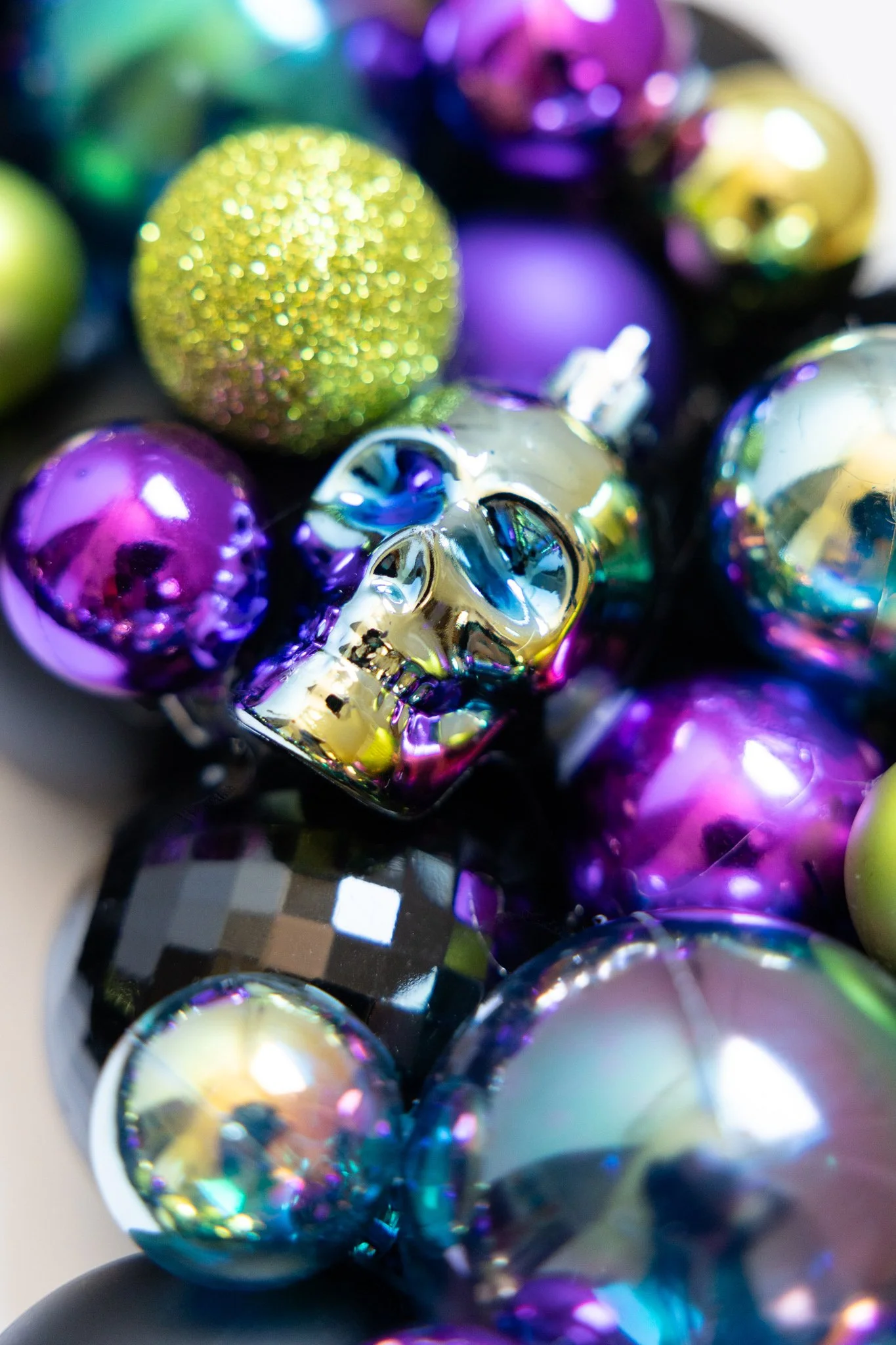 Halloween ornament wreath with black, purple, green and iridescent skull ornaments