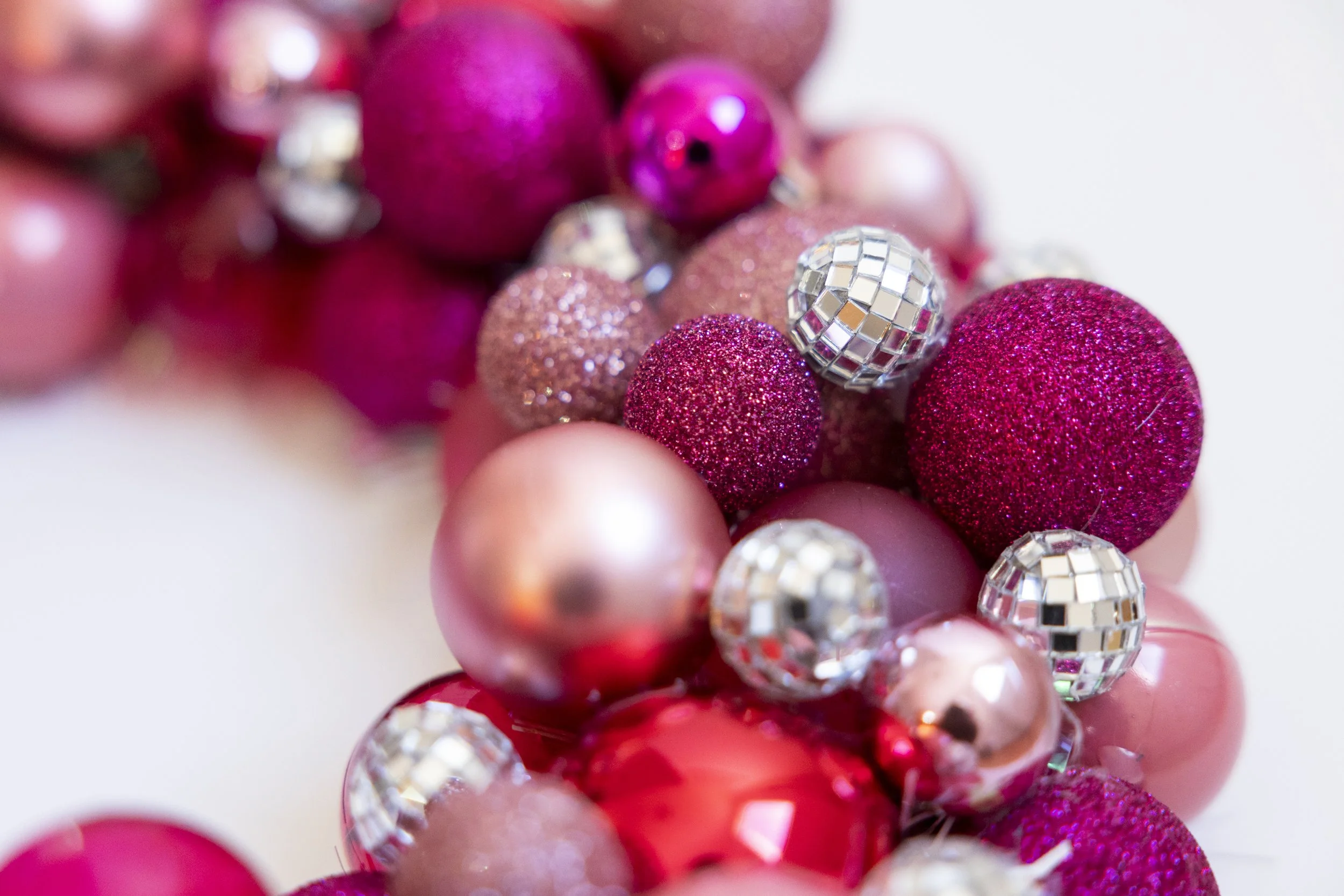 Handmade wreath with pink ornaments and shiny disco balls