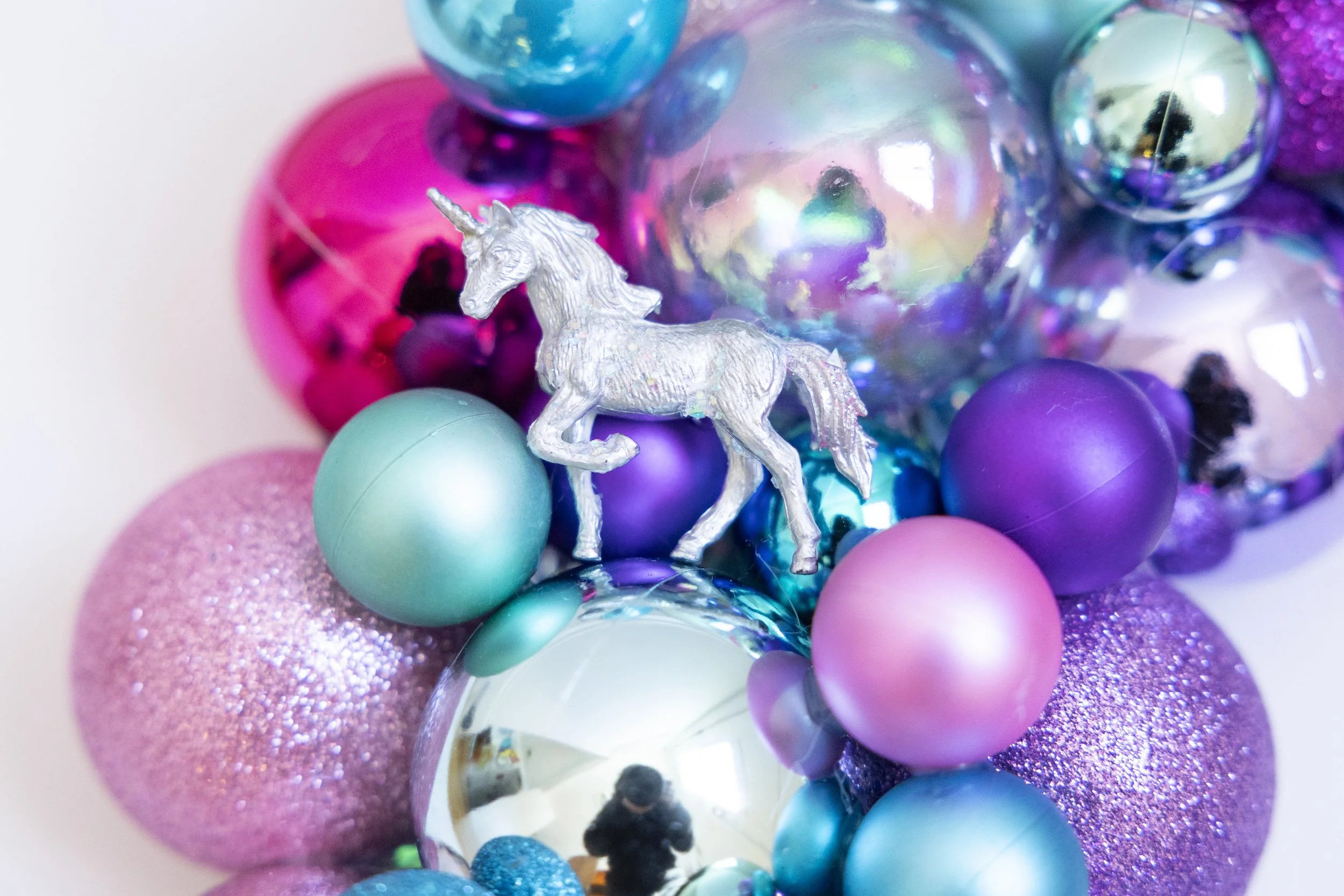 Sparkly silver unicorn on colorful ornament wreath