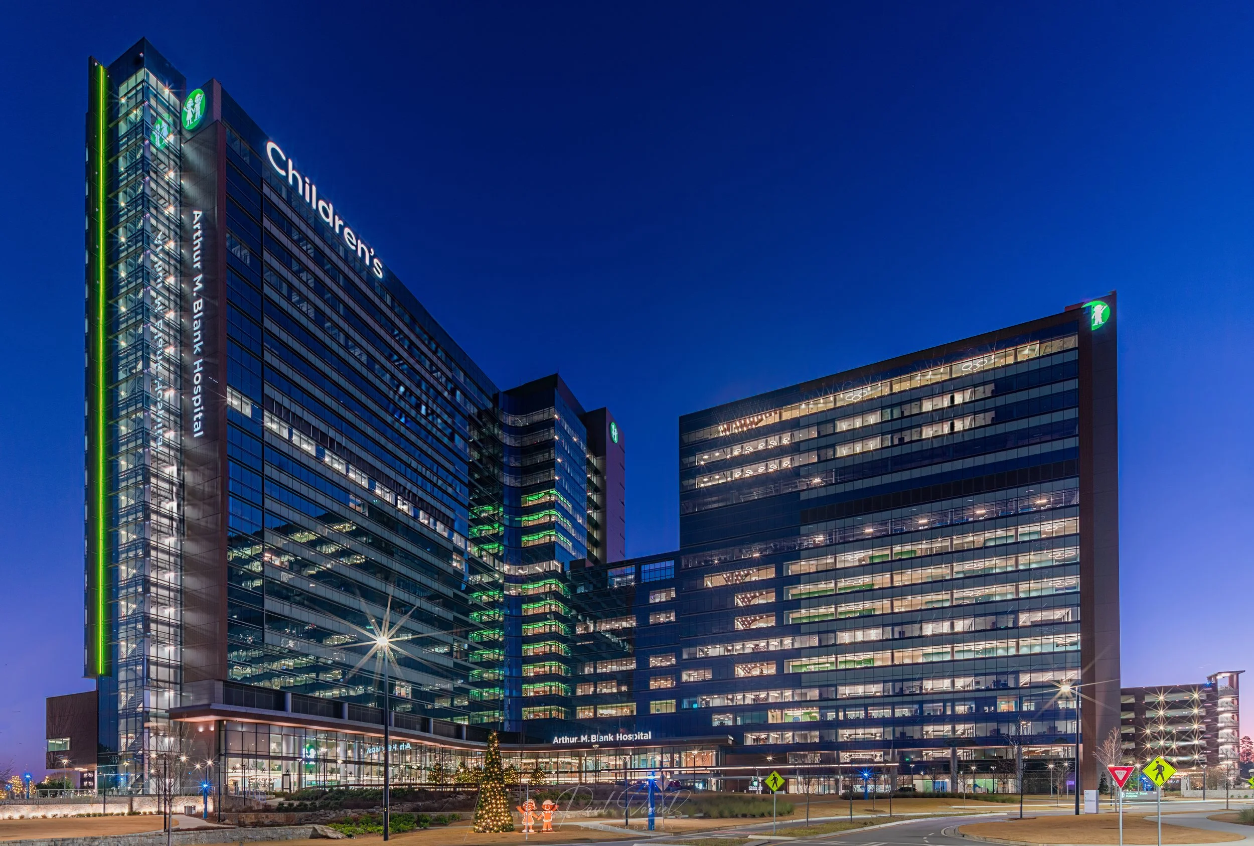 Twilight exterior view of the Arthur M. Blank Hospital at Children's Healthcare of Atlanta, showcasing its illuminated modern glass facade and pediatric medial campus in Atlanta, GA - Brookhaven, GA