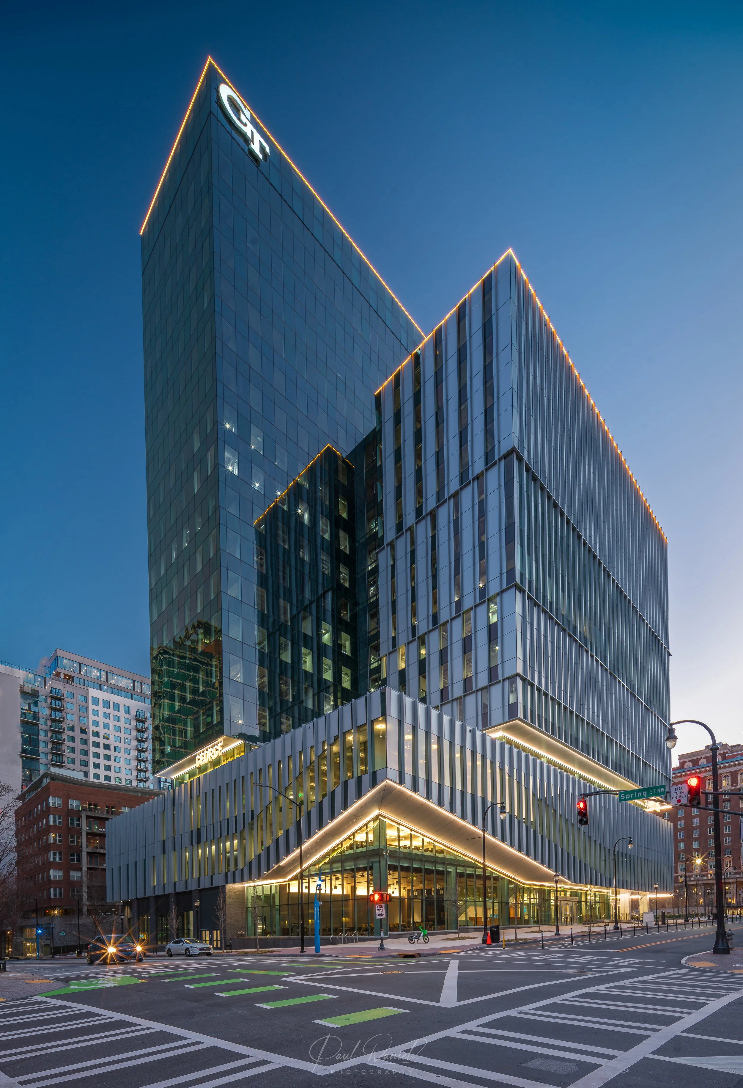 Modern architectural twilight view of the Scheller Tower at. Georgia Tech's Tech Square, featuring geometric glass facades and illuminated roofline accents in Midtown Atlanta