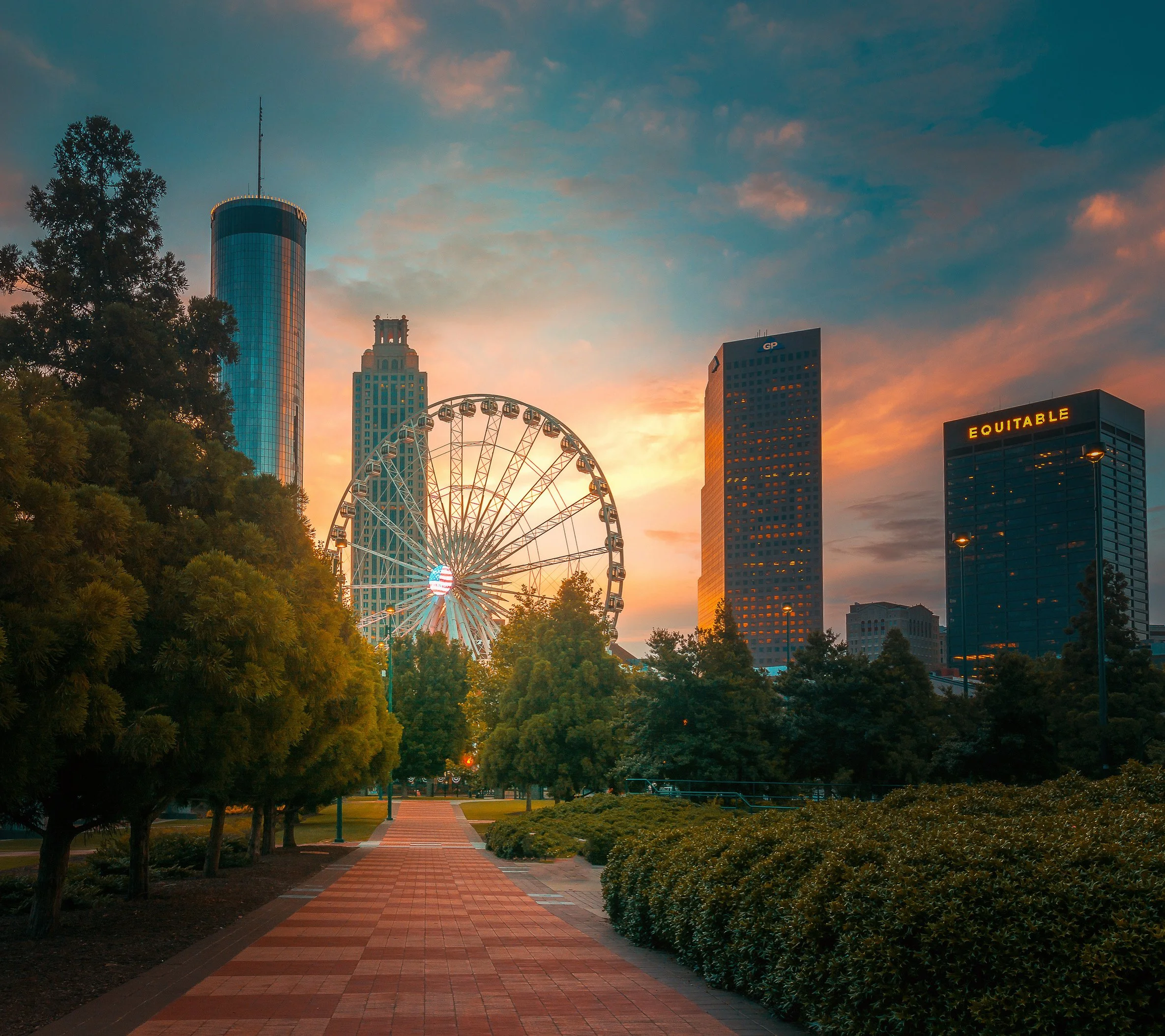 +Sunrise over Centennial Olympic Park pathway featuring Skyview Atlanta Ferris wheel, Westin Peachtree Plaza and the Downtown Atlanta skyline. 