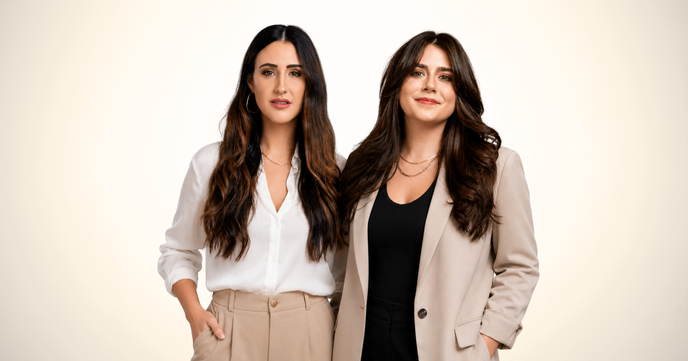 Two women standing side by side against a plain light background, dressed in professional attire, with confident expressions.
