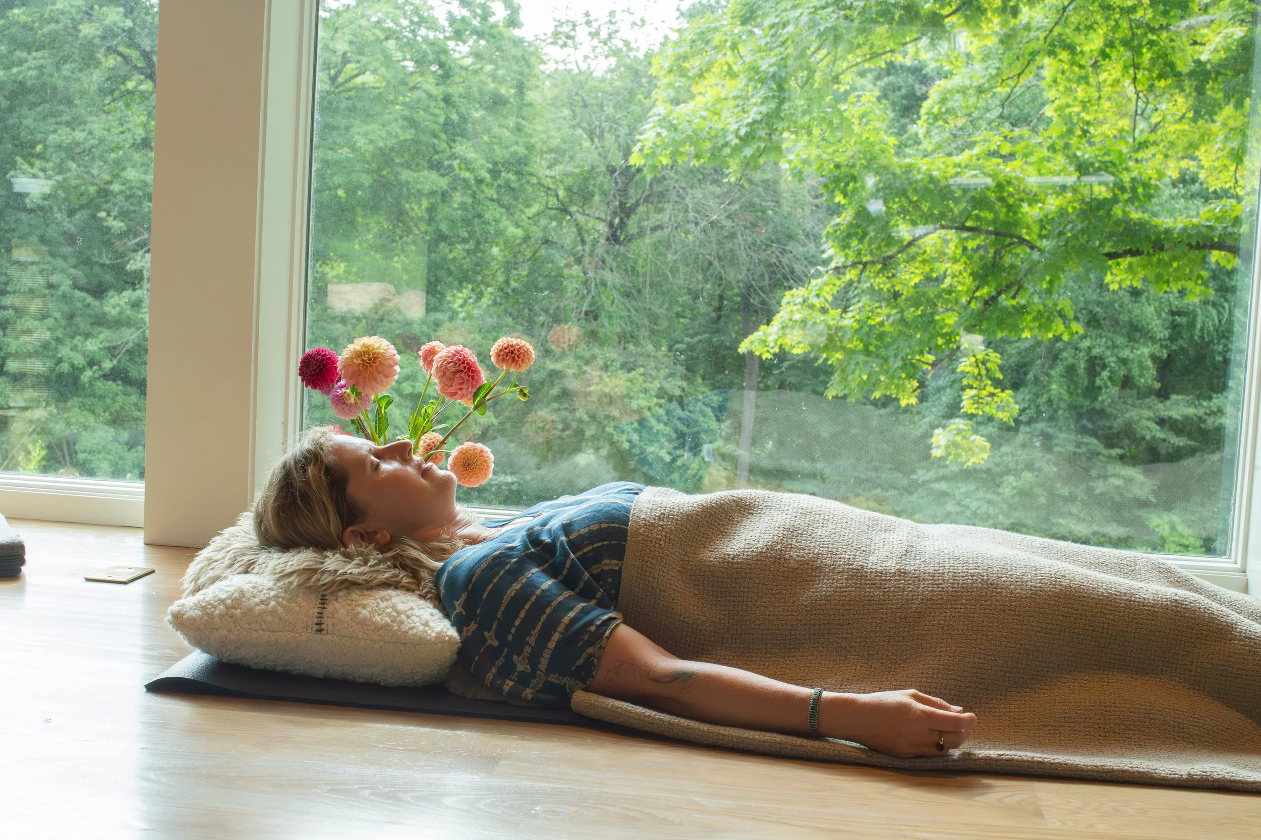 Middle-aged woman resting in Yoga Nidra in a beautiful, natural setting