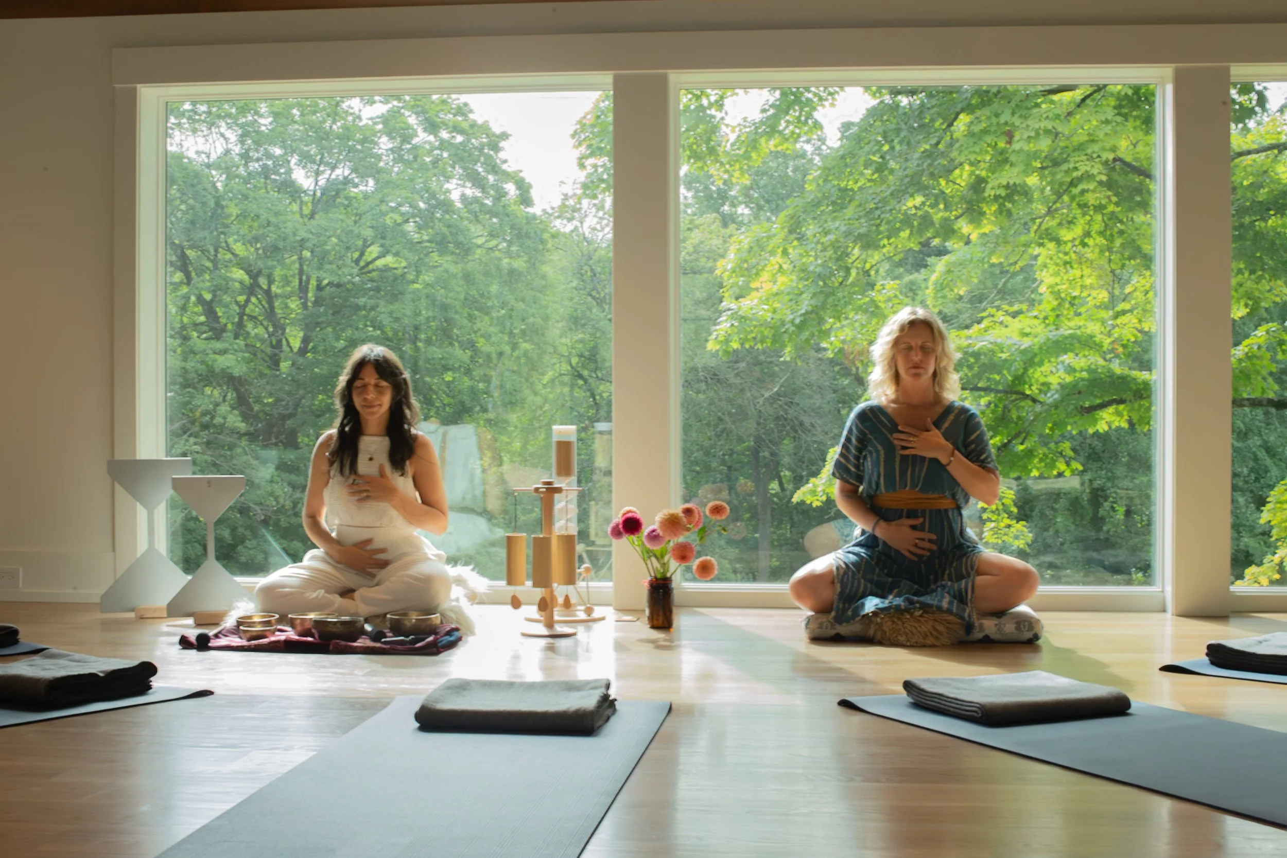 Two women facilitating Yoga Nidra, meditation and sound bath in a comfortable setting