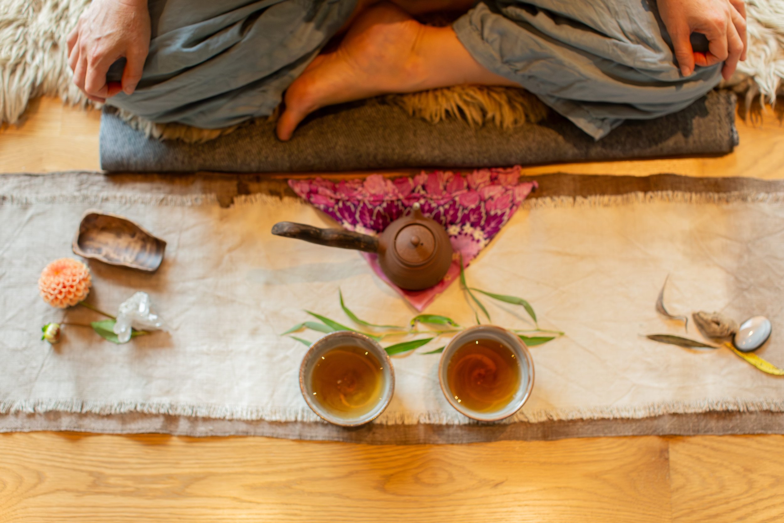 Meditation teacher performing a tea ceremony on a mat