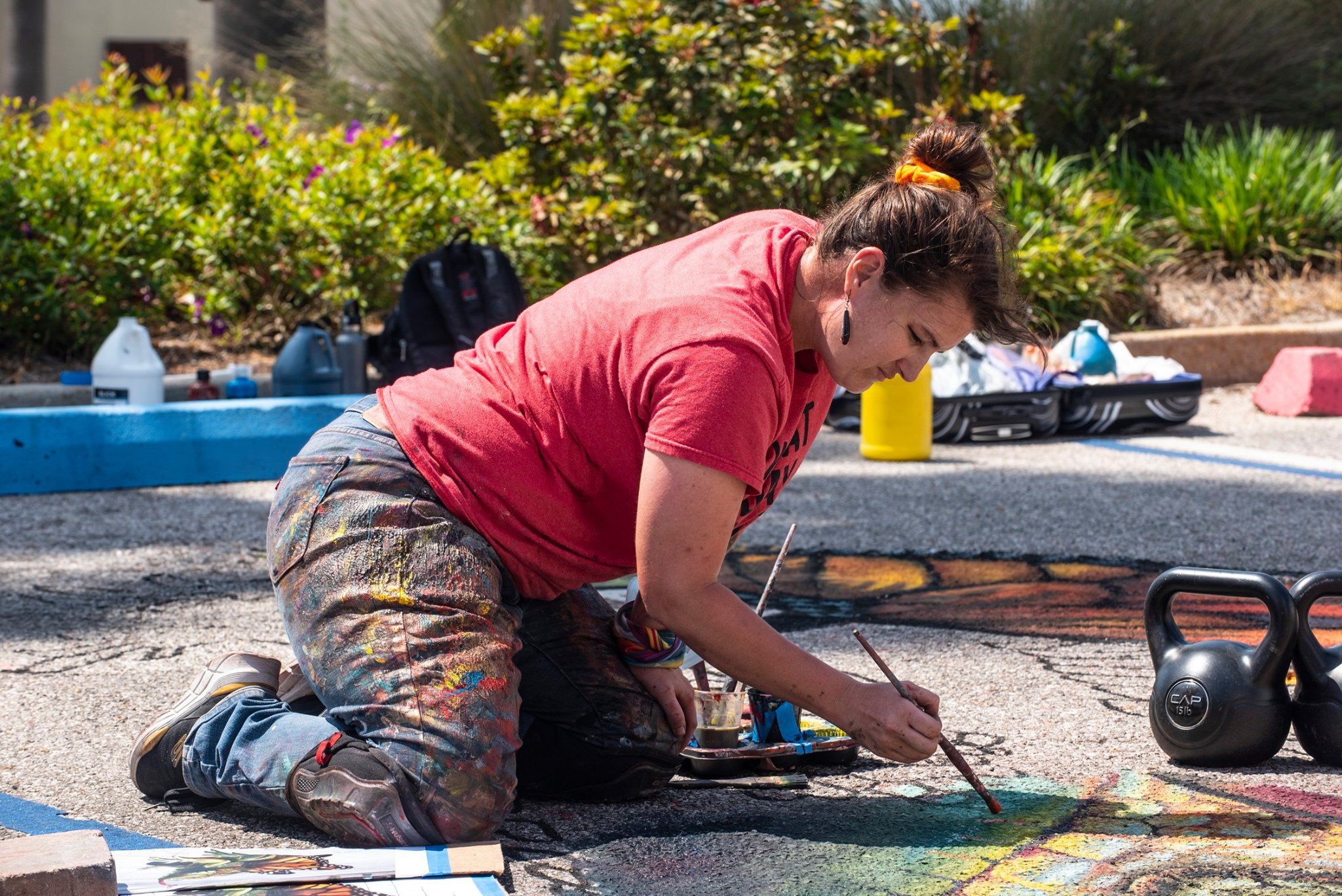 Artist creating artwork at the FLLUX Arts Festival in downtown Panama City, Florida, with the Center for the Arts in the background.