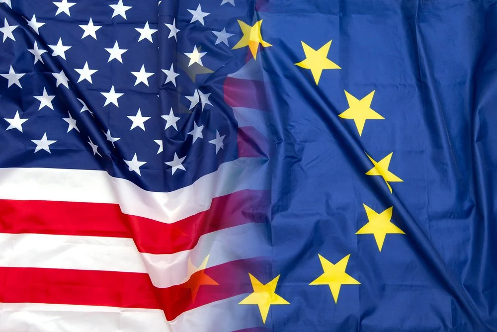 An American flag and a European Union flag overlapping each other.