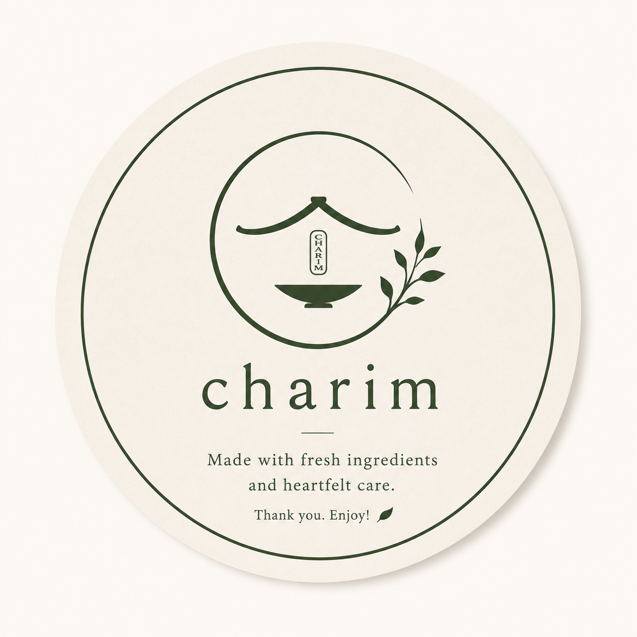A round label with a minimalist logo of a smiling face with closed eyes, a mustache, and a branch with leaves. The text reads 'charim' and 'Made with fresh ingredients and heartfelt care. Thank you. Enjoy!'