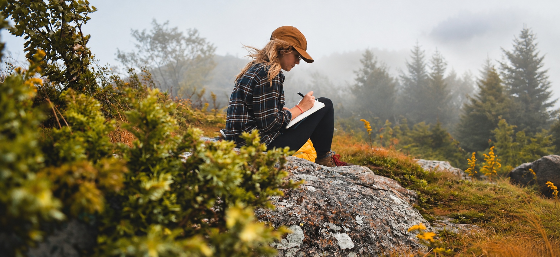 Beyond capacity therapy woman sitting in nature writing in notebook
