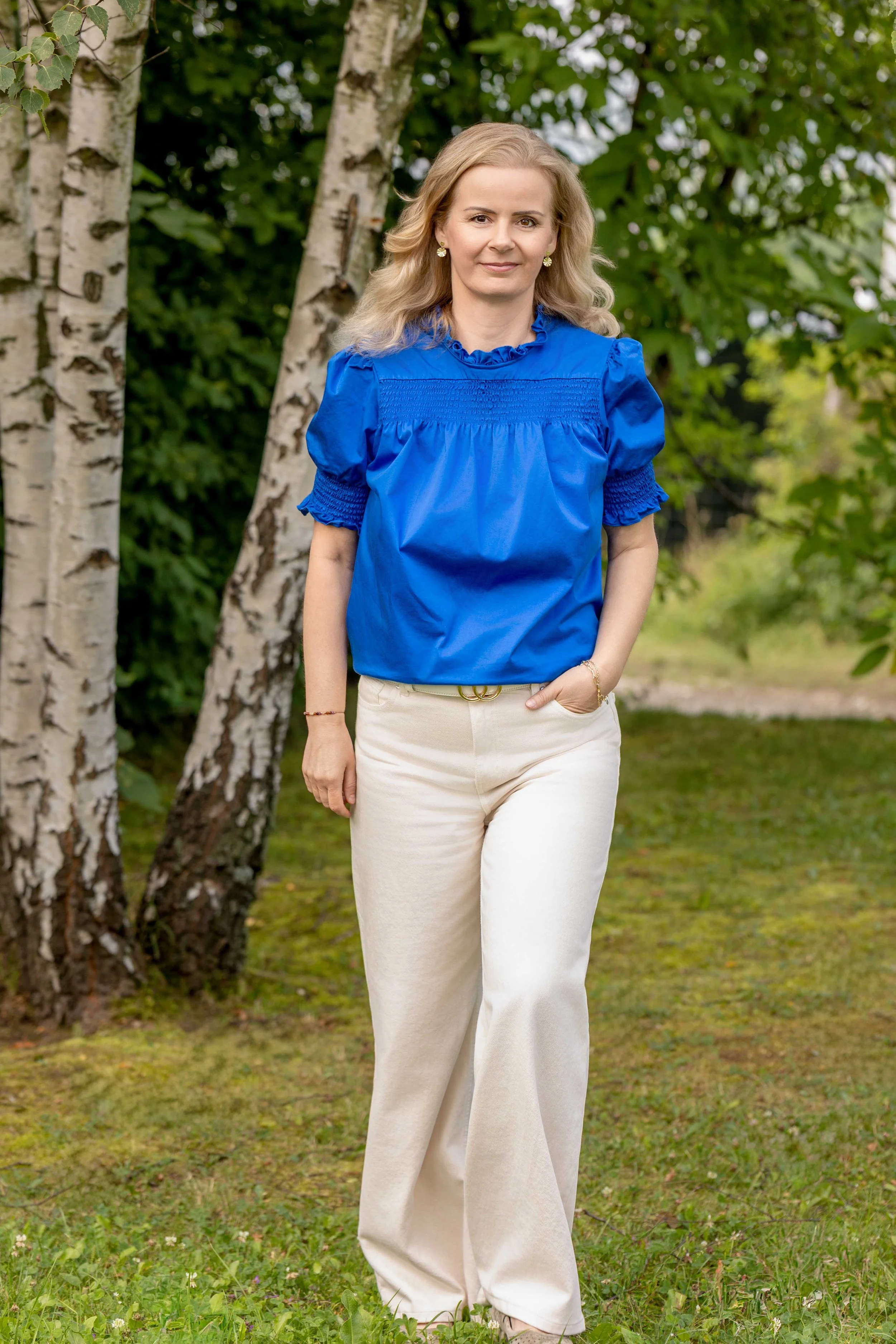Agnieszka Hinczyca, coach, stojąca wśród brzóz w naturalnym otoczeniu